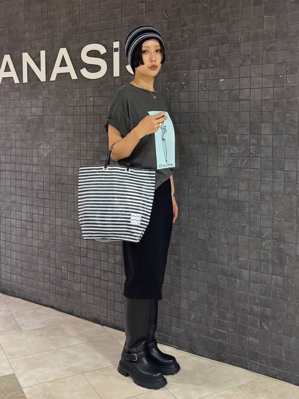 ブラック系のスカート、グレー系のTシャツ/カットソー、ブラック系のブーツを着用したレディースの夏コーディネートの2枚目の写真