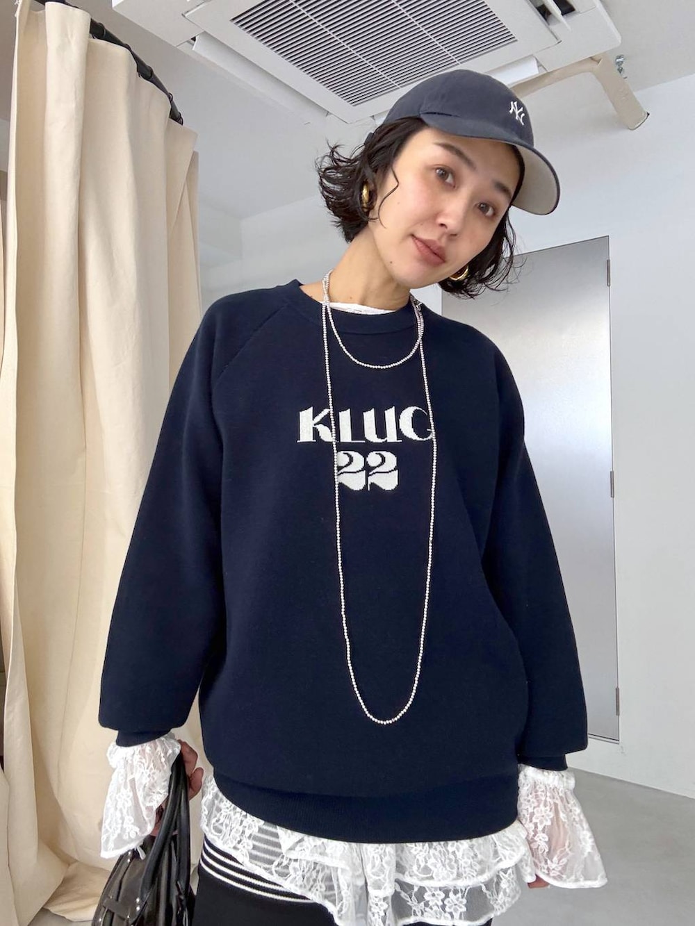 ブラック系のボストンバッグ、ホワイト系のシャツ/ブラウスを着用したレディースの秋コーディネートの6枚目の写真