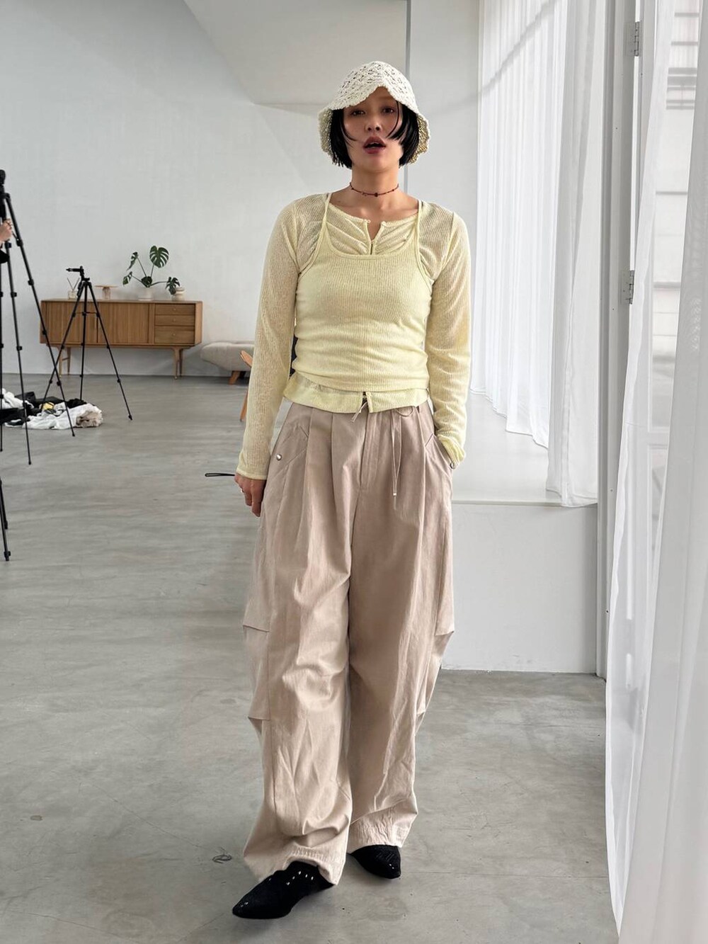 ブラック系のパンプス、ベージュ系のその他パンツ、イエロー系のカーディガン/ボレロを着用したレディースの春コーディネートの4枚目の写真