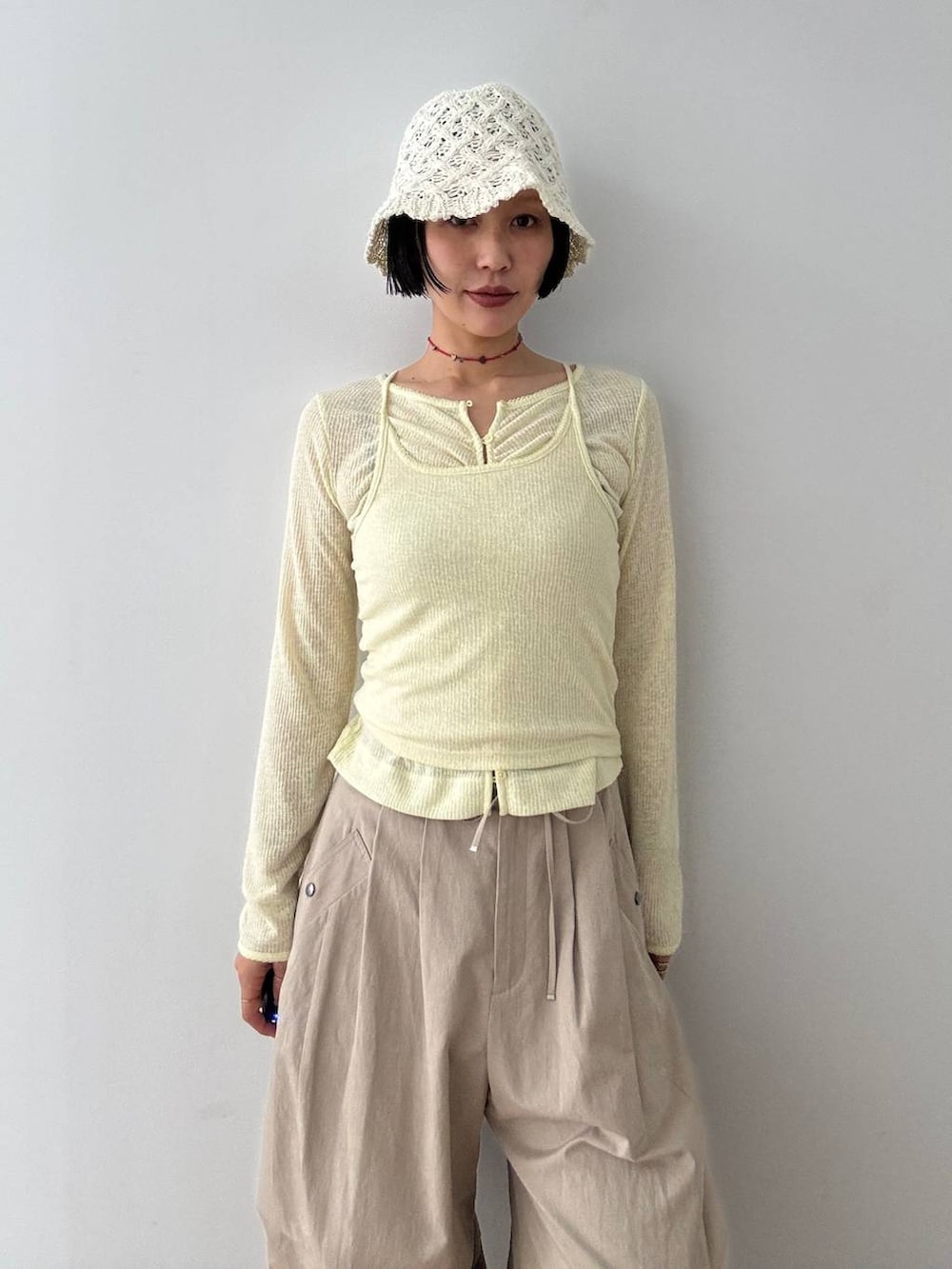 ブラック系のパンプス、ベージュ系のその他パンツ、イエロー系のカーディガン/ボレロを着用したレディースの春コーディネートの6枚目の写真