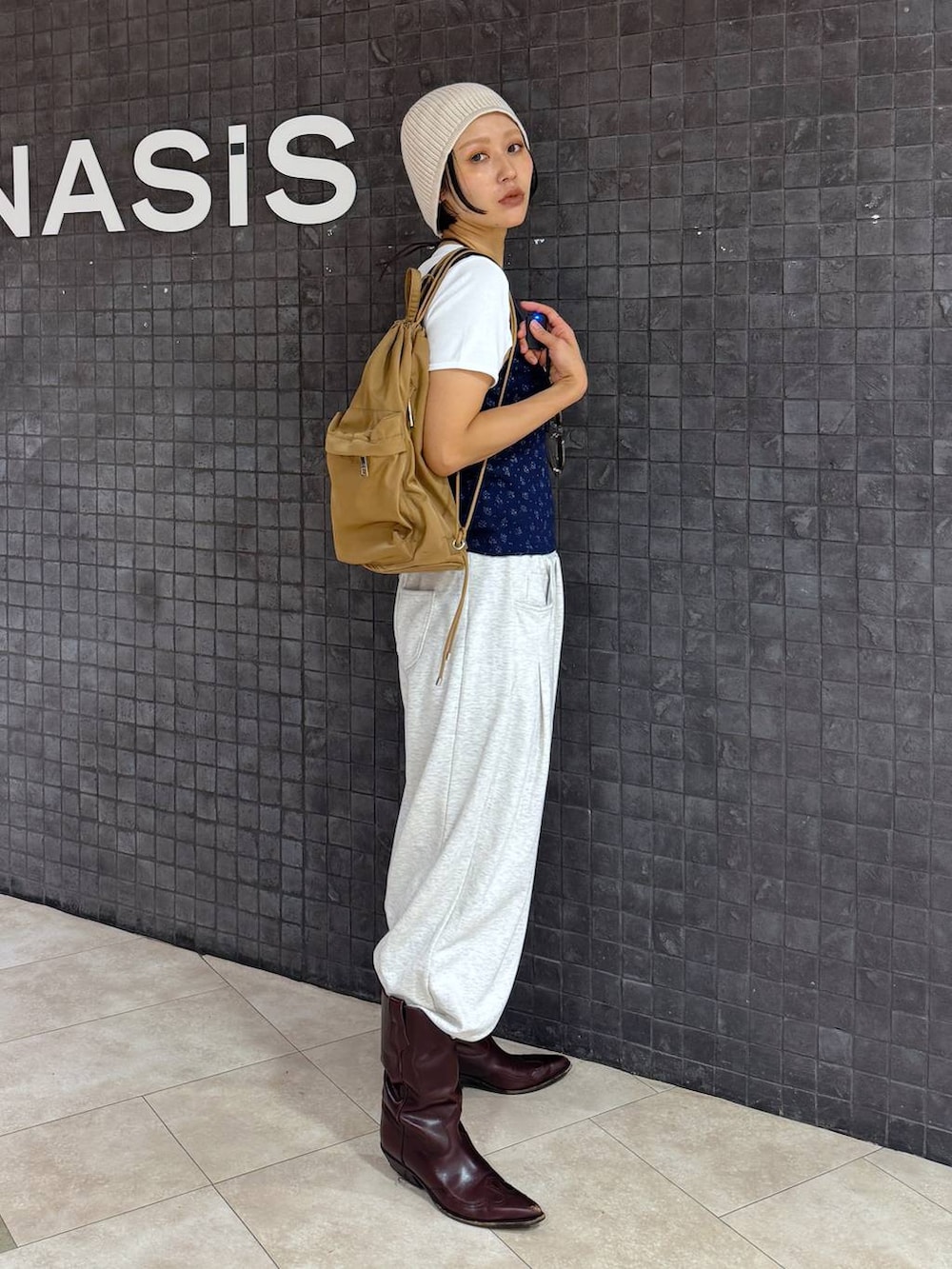 ブルー系のタンクトップ、ホワイト系のTシャツ/カットソー、ベージュ系のスウェットパンツを着用したレディースの夏コーディネートの2枚目の写真