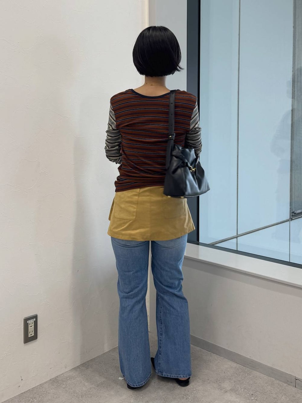 ブラック系のショルダーバッグ、ブルー系のデニムパンツ、ブラック系のサンダルを着用したレディースの夏コーディネートの3枚目の写真