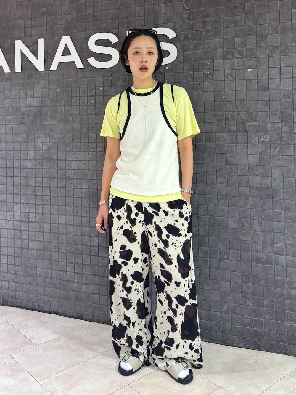 ベージュ系のその他パンツ、ホワイト系のサンダル、イエロー系のTシャツ/カットソーを着用したレディースの夏コーディネートの2枚目の写真