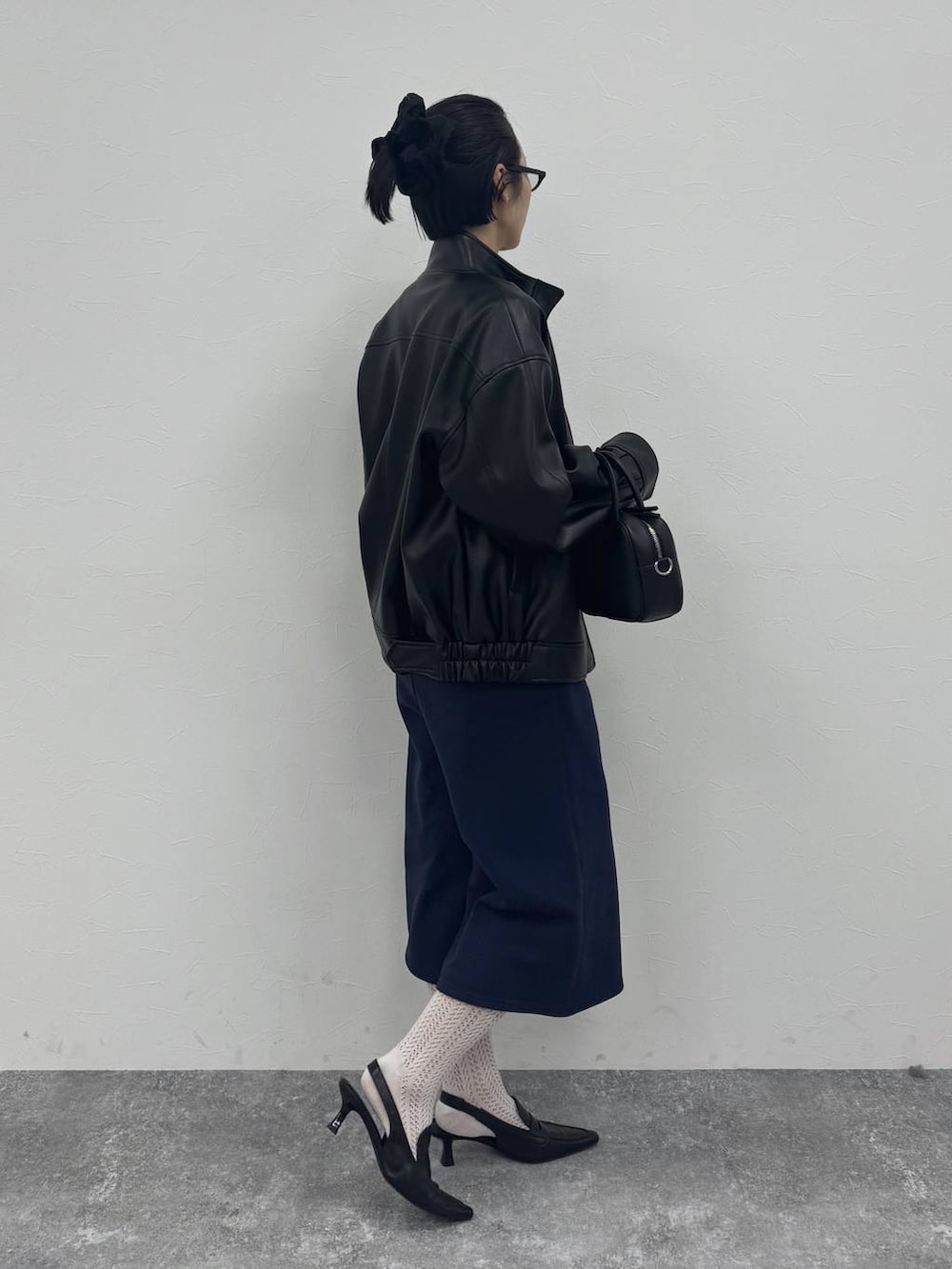 ブラック系のローファー、ブラック系のショルダーバッグ、ブラック系のブルゾンを着用したレディースの冬コーディネートの5枚目の写真