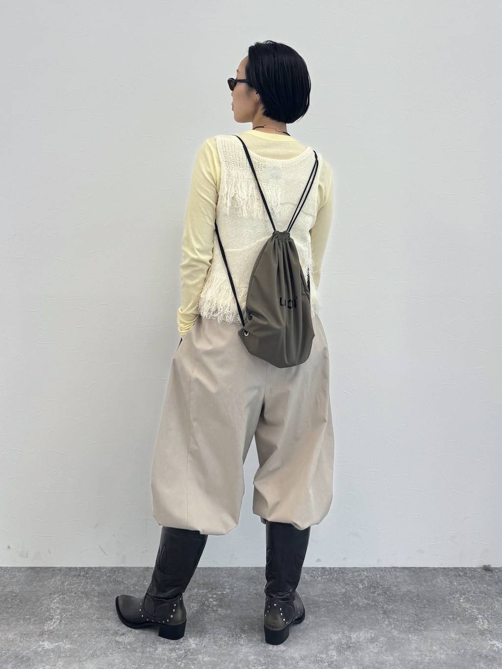 ブラック系のブーツ、イエロー系のTシャツ/カットソー、ベージュ系のその他パンツを着用したレディースの冬コーディネートの4枚目の写真