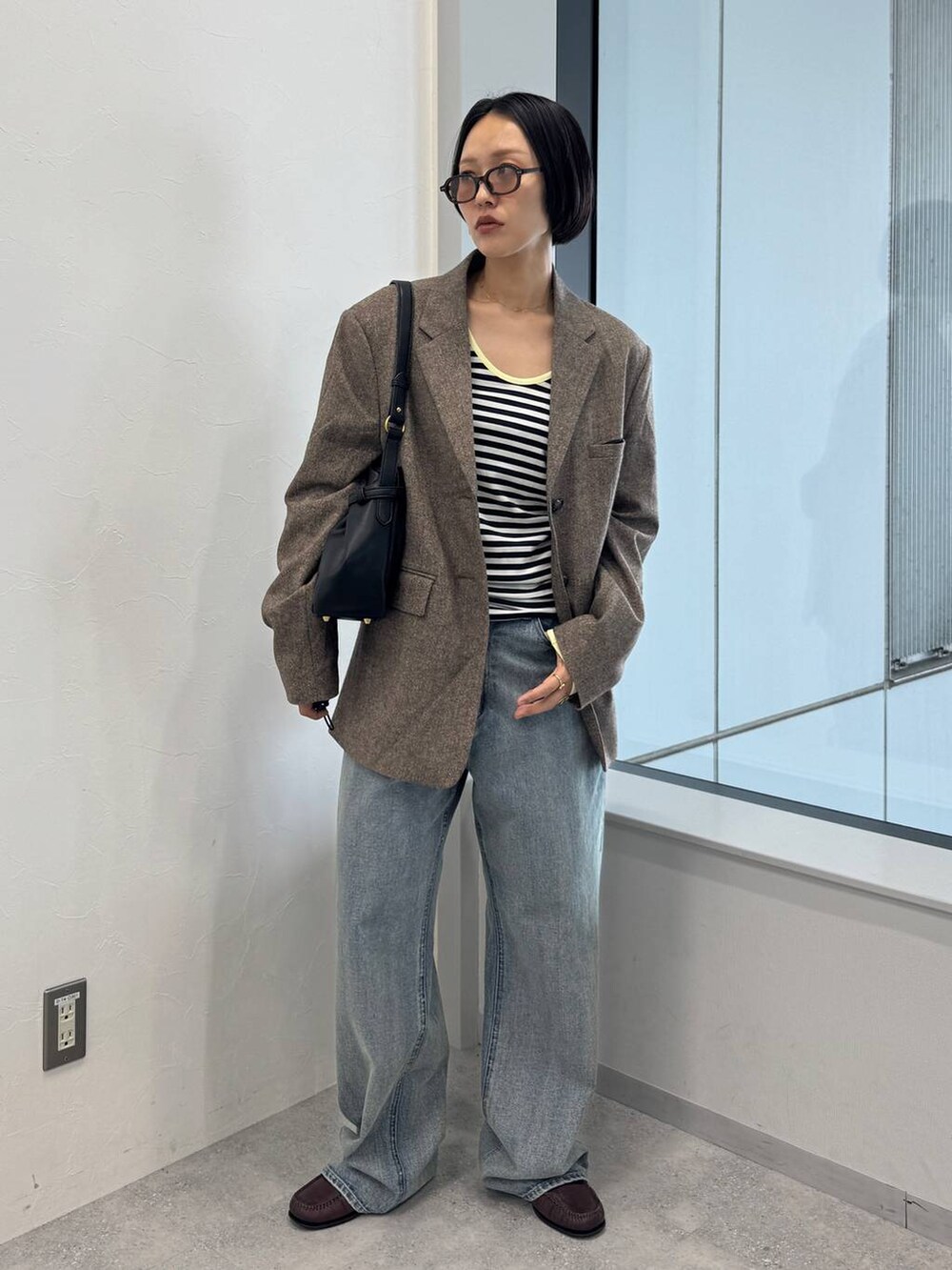 ブルー系のデニムパンツ、ブラック系のショルダーバッグを着用したレディースの夏コーディネートの2枚目の写真