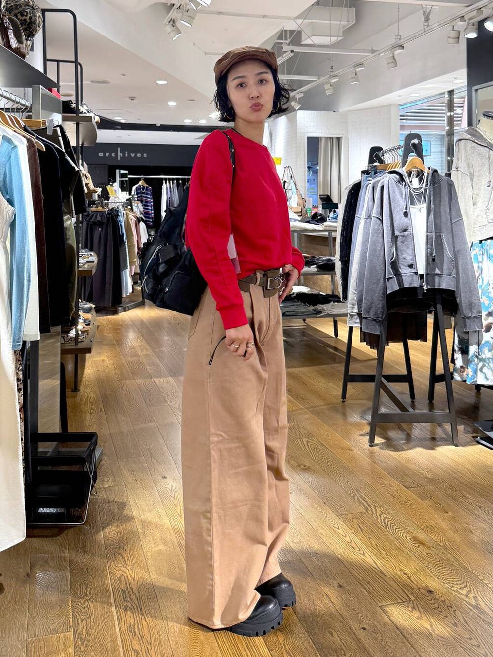 ベージュ系のデニムパンツ、ブラック系のショルダーバッグ、ブラック系のブーツを着用したレディースの秋コーディネートの4枚目の写真