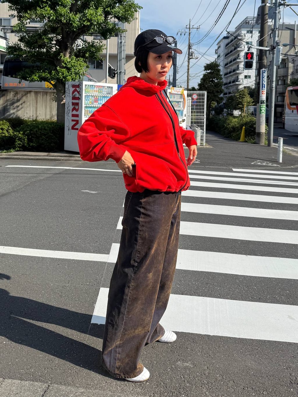 ブラウン系のデニムパンツ、レッド系のパーカーを着用したレディースの夏コーディネートの3枚目の写真
