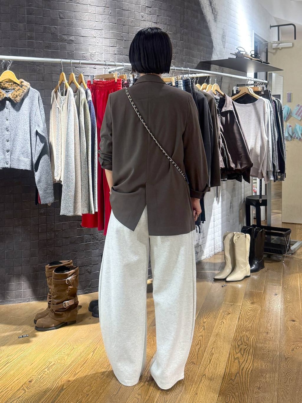 ブラック系のパンプス、ブラウン系のテーラードジャケット、ベージュ系のスウェットパンツを着用したレディースの秋コーディネートの3枚目の写真