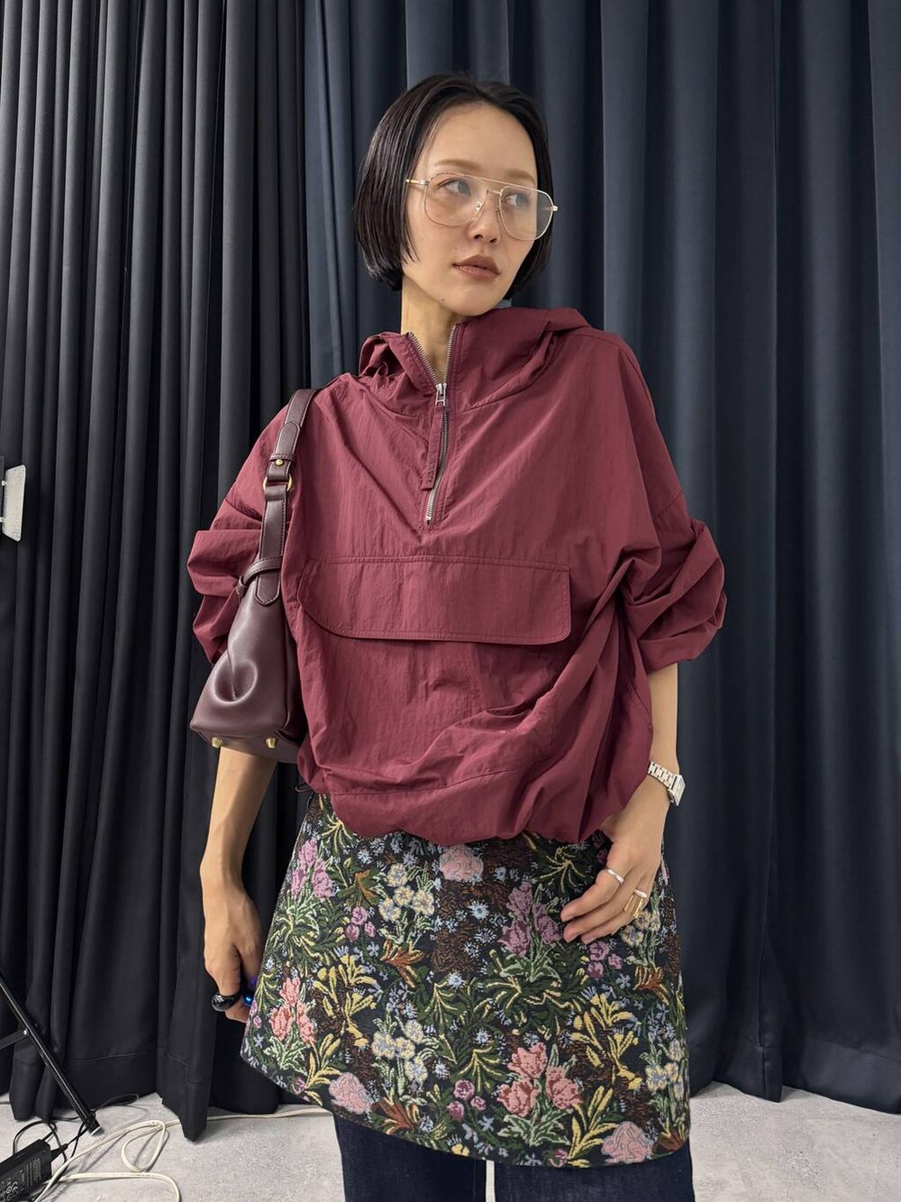 レッド系のショルダーバッグ、ブルー系のデニムパンツ、ブラック系のスカートを着用したレディースの夏コーディネートの4枚目の写真