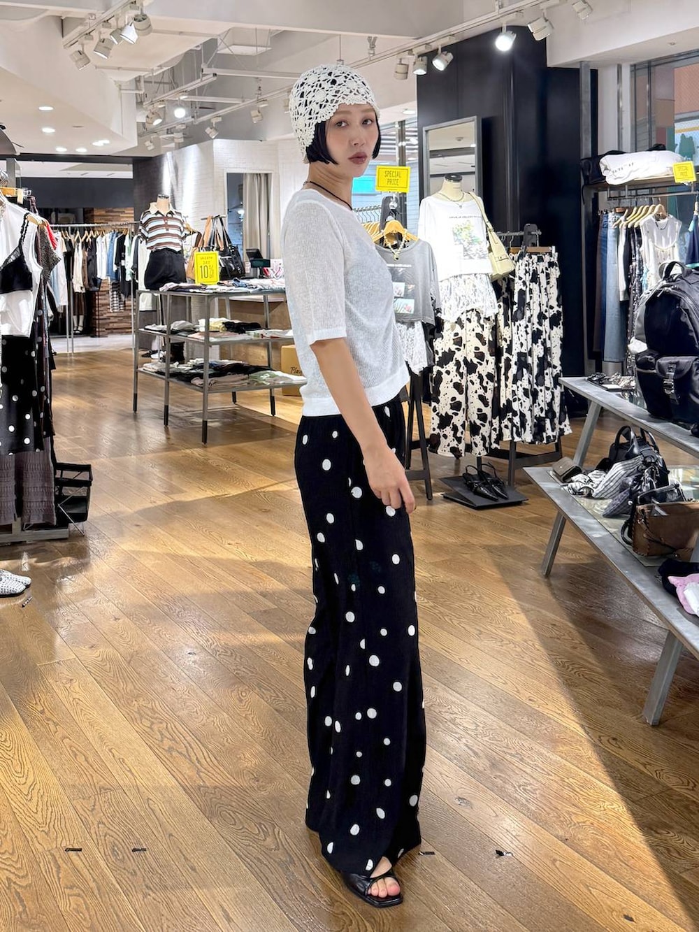 ブラック系のその他パンツ、ホワイト系のカーディガン/ボレロ、ブラック系のパンプスを着用したレディースの夏コーディネートの3枚目の写真
