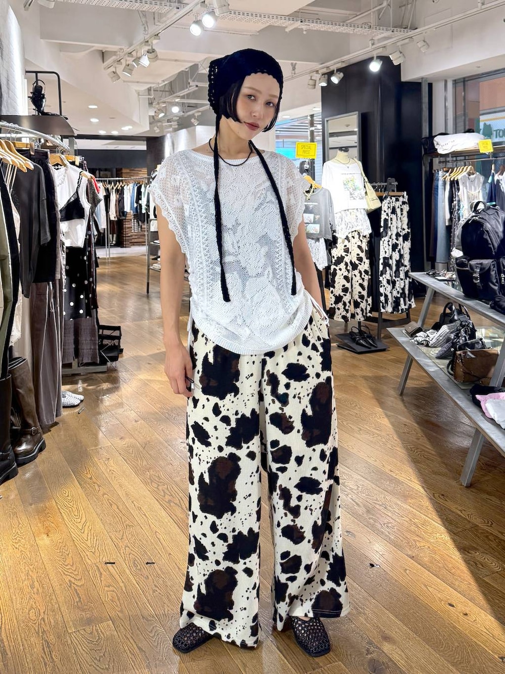 ベージュ系のその他パンツ、ホワイト系のニット/セーター、ブラック系のパンプスを着用したレディースの夏コーディネートの3枚目の写真