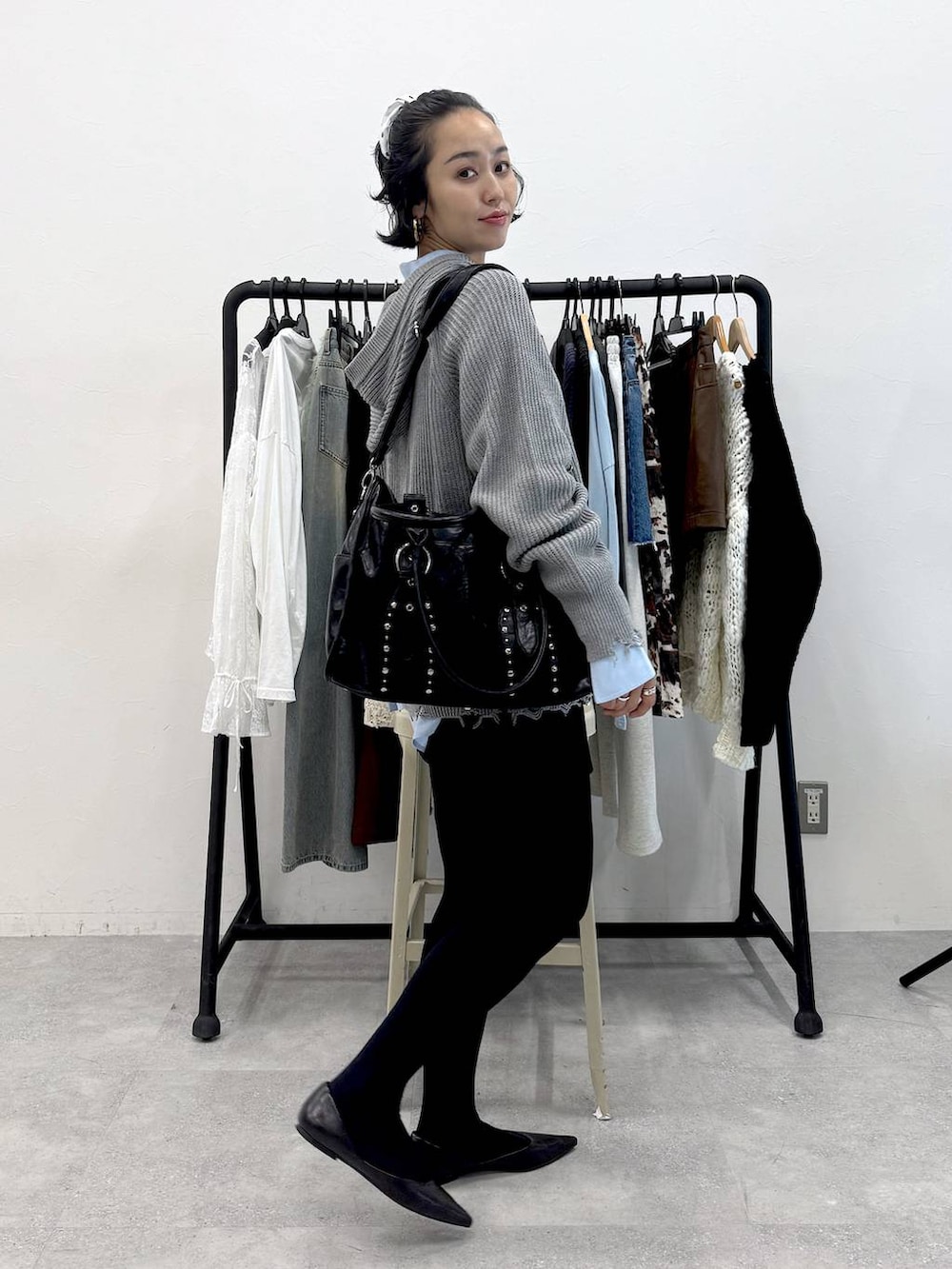 ブラック系のトートバッグ、ブルー系のシャツ/ブラウス、ブラック系のスカートを着用したレディースの秋コーディネートの3枚目の写真