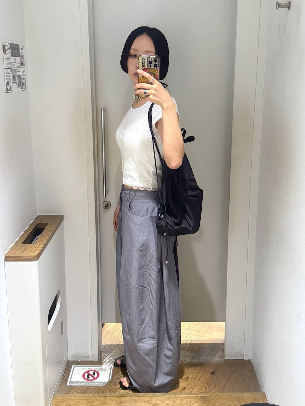 ブラック系のパンプス、グレー系のスラックス、ホワイト系のカーディガン/ボレロを着用したレディースの春コーディネートの2枚目の写真