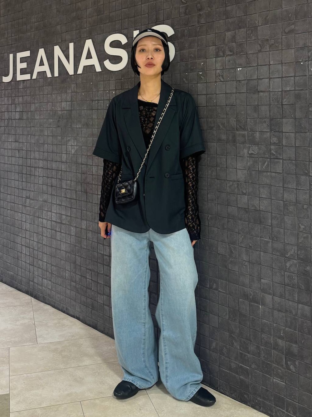 ブラック系のTシャツ/カットソー、ブルー系のデニムパンツ、グレー系のテーラードジャケットを着用したレディースの春コーディネートの6枚目の写真