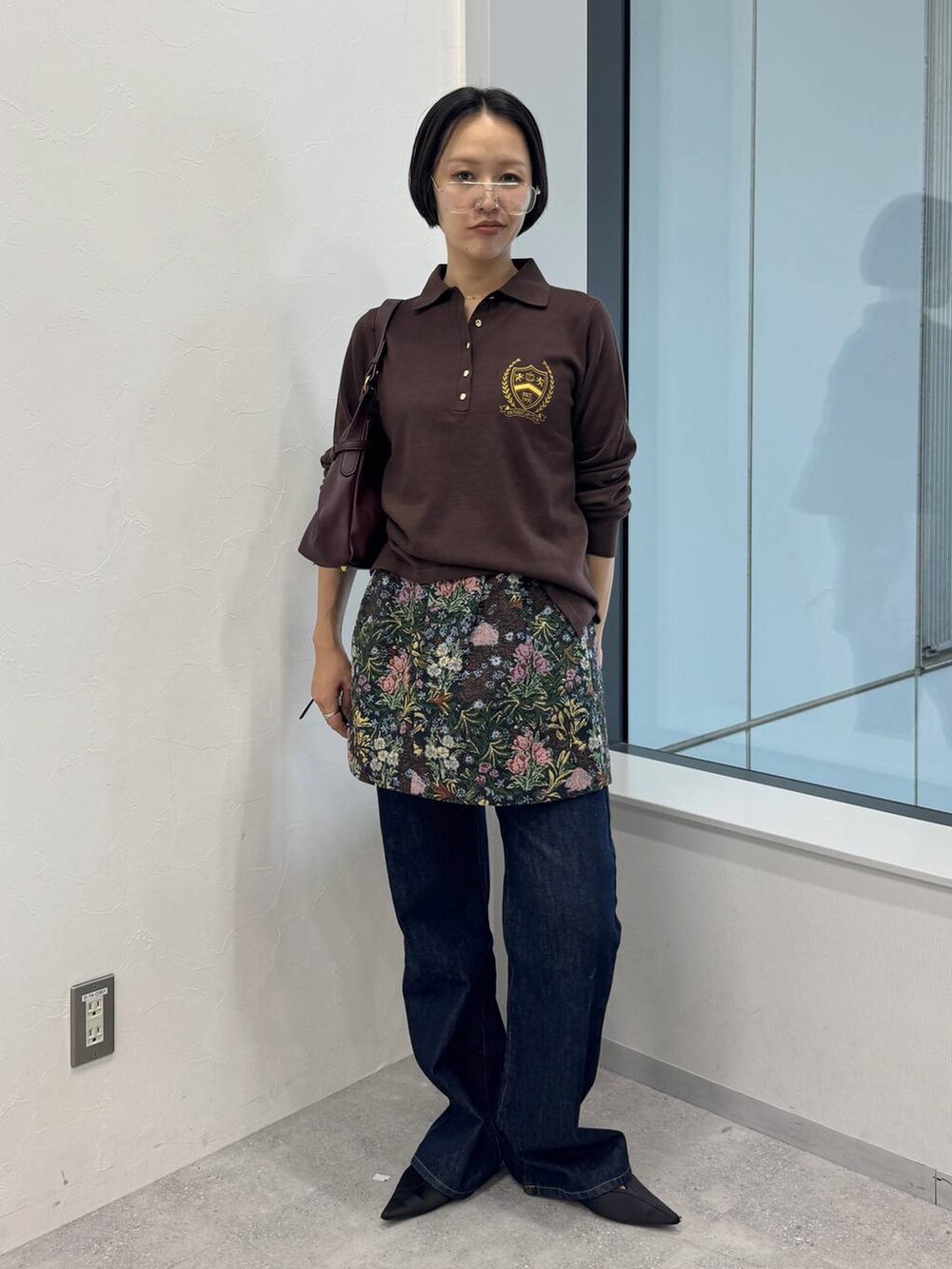 レッド系のショルダーバッグ、ブルー系のデニムパンツ、ブラック系のスカートを着用したレディースの夏コーディネートの4枚目の写真