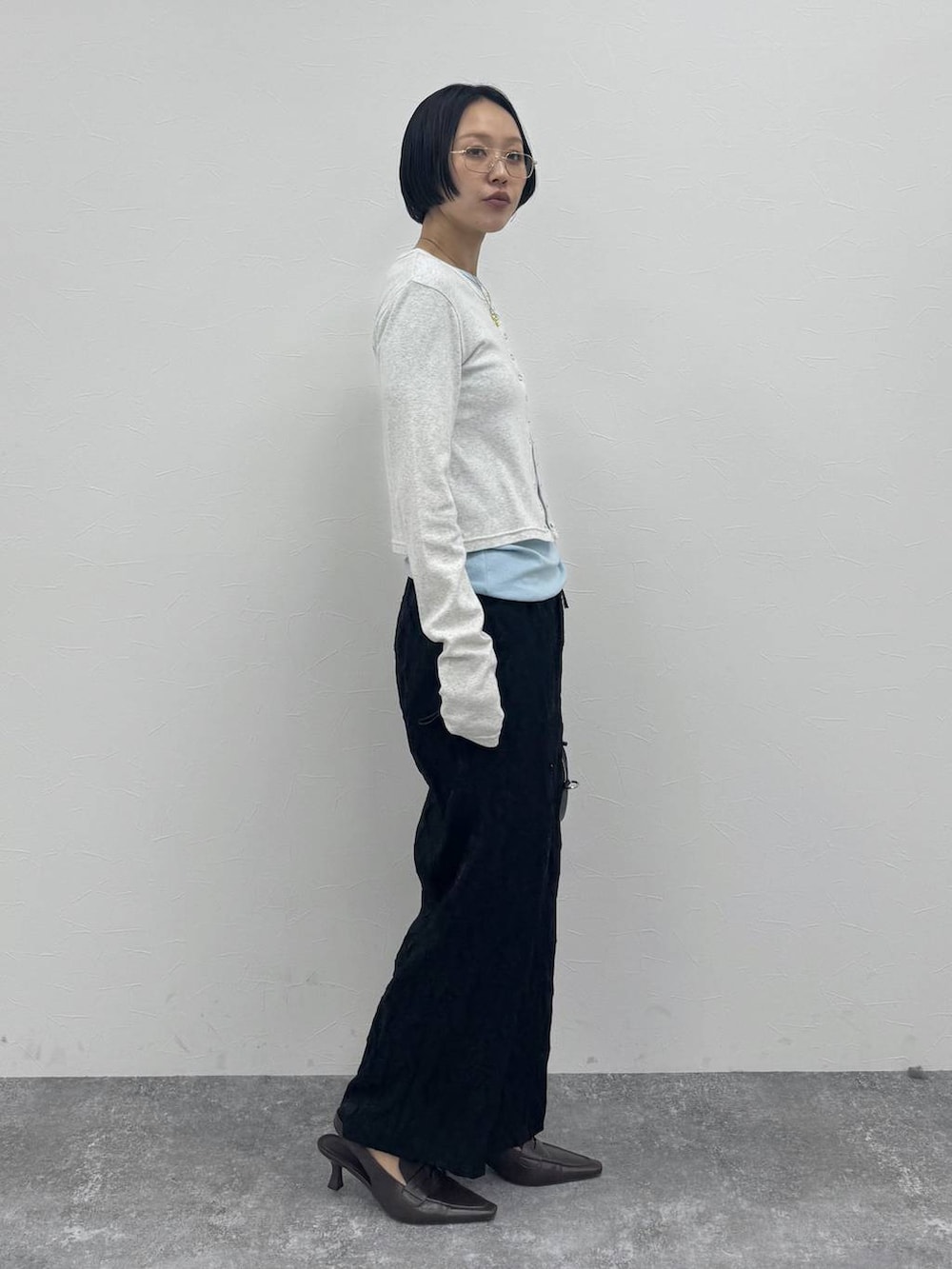 ブラウン系のローファー、ブラック系のショルダーバッグを着用したレディースの冬コーディネートの4枚目の写真