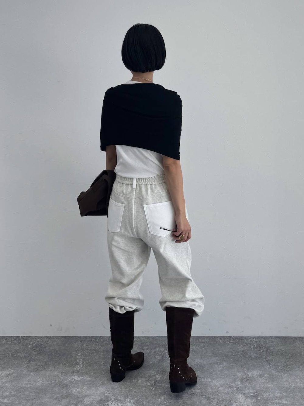 ブラック系のブーツ、ブラウン系のショルダーバッグを着用したレディースの冬コーディネートの4枚目の写真