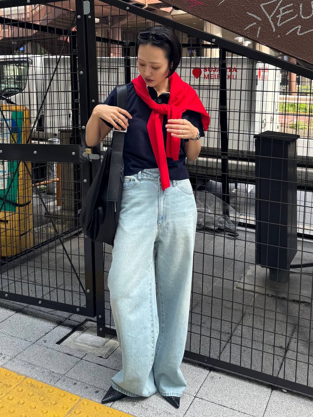 ブラック系のパンプス、ブルー系のデニムパンツを着用したレディースの春コーディネートの4枚目の写真