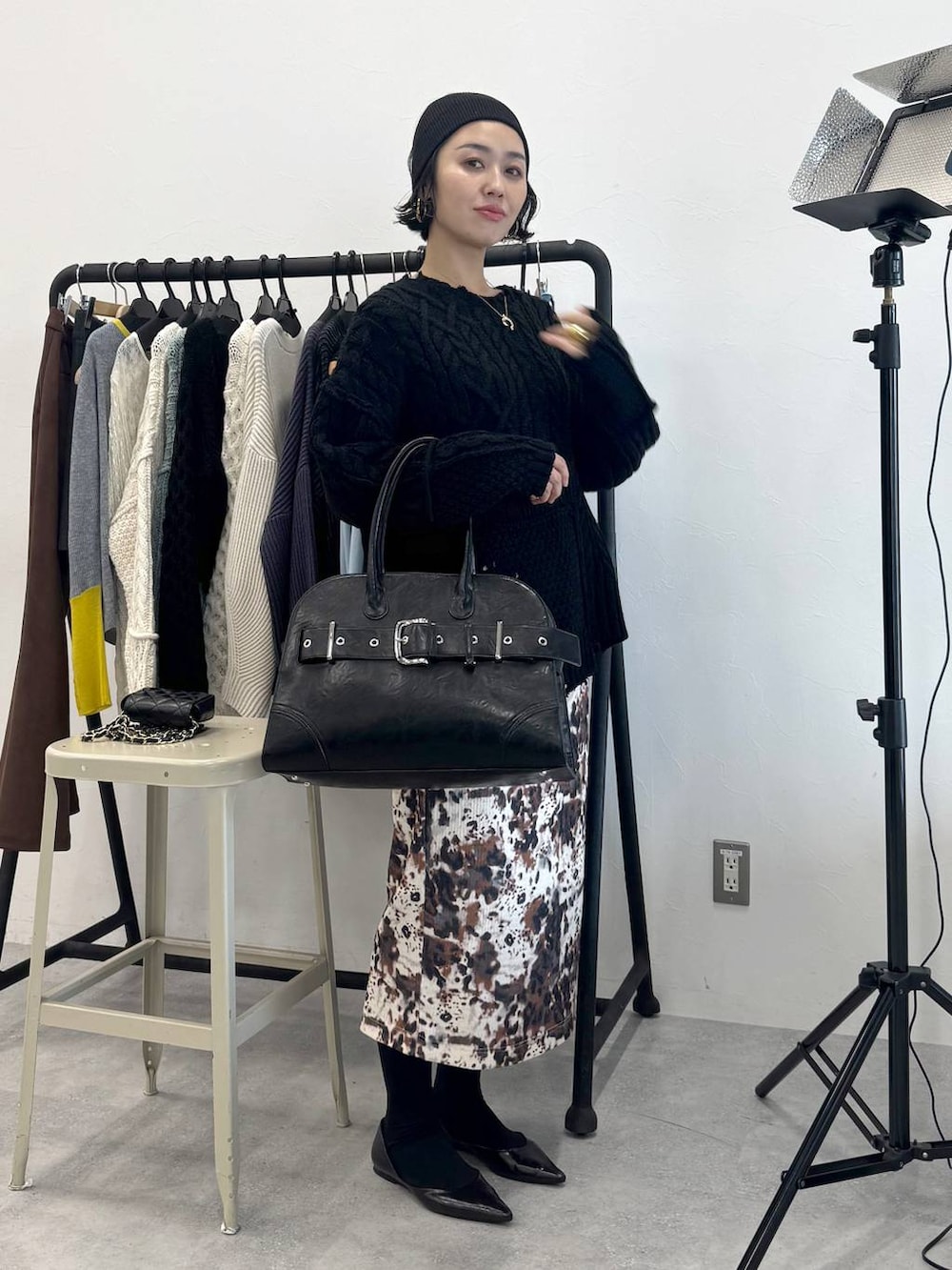 ベージュ系のスカート、ブラック系のショルダーバッグ、ブラック系のニット/セーターを着用したレディースの秋コーディネートの3枚目の写真