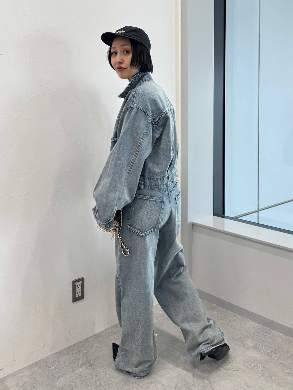 ブルー系のデニムジャケット、ブルー系のデニムパンツ、ブラック系のサンダルを着用したレディースの夏コーディネートの2枚目の写真