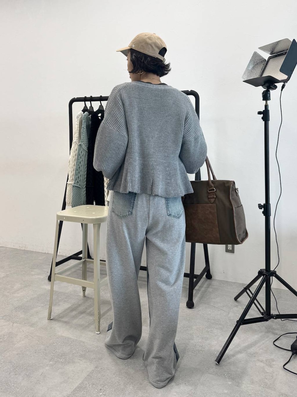 ブルー系のデニムパンツ、グリーン系のトートバッグ、グレー系のTシャツ/カットソーを着用したレディースの秋コーディネートの3枚目の写真