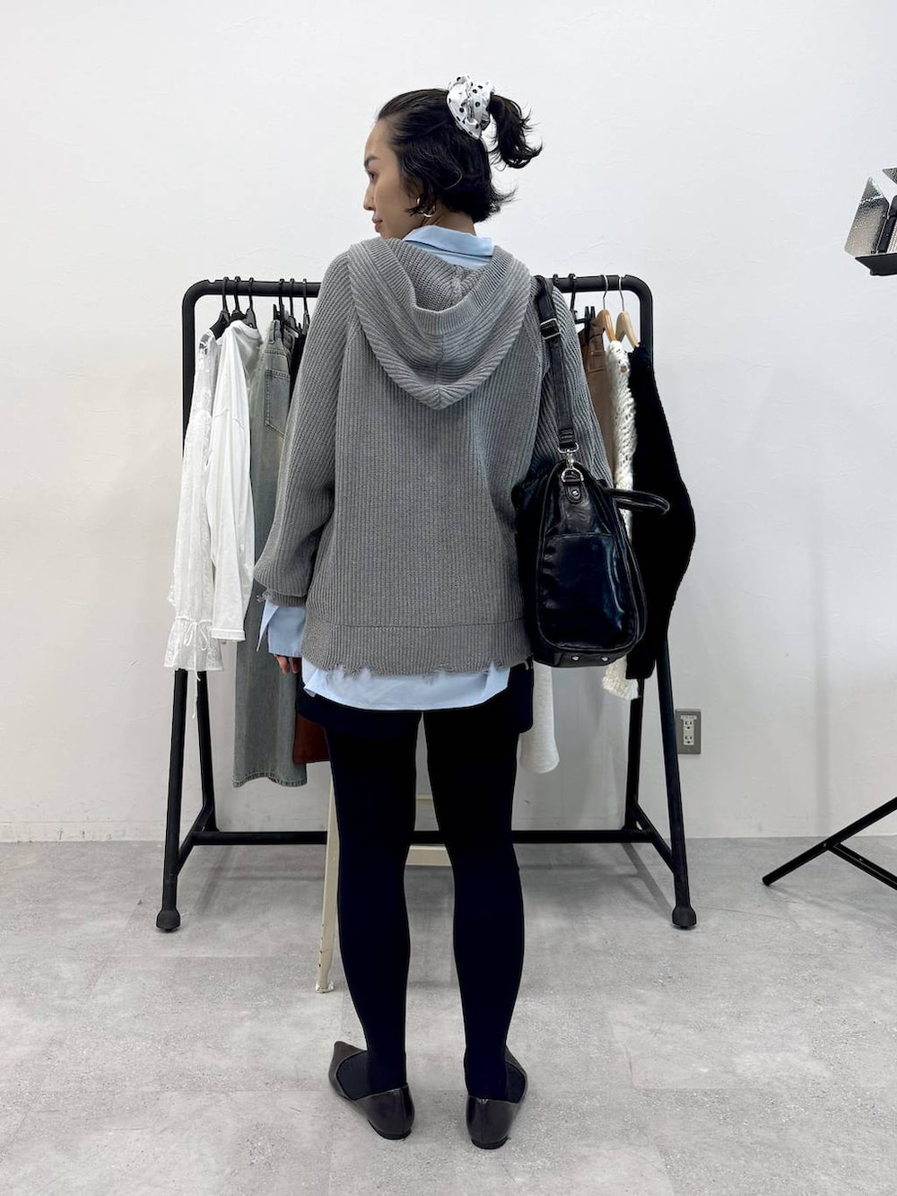 ブラック系のトートバッグ、ブルー系のシャツ/ブラウス、ブラック系のスカートを着用したレディースの秋コーディネートの4枚目の写真