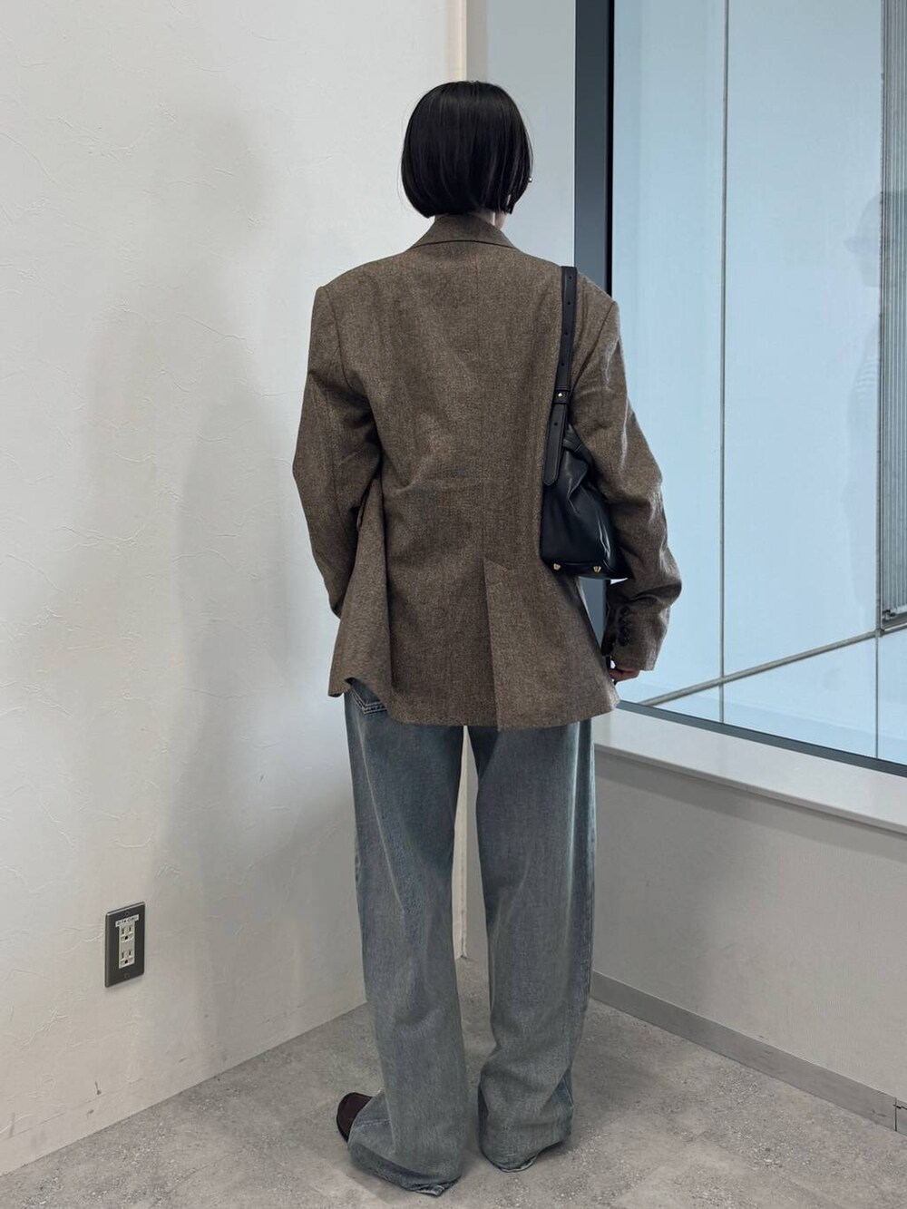 ブルー系のデニムパンツ、ブラック系のショルダーバッグを着用したレディースの夏コーディネートの4枚目の写真