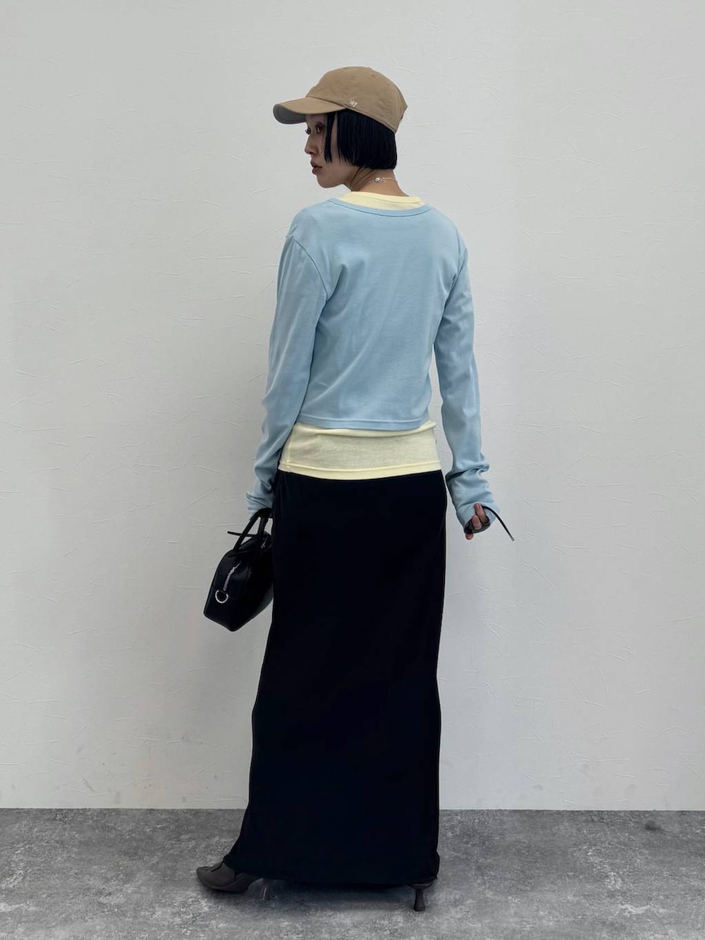 ブラウン系のローファー、ブラック系のショルダーバッグ、ブラック系のスカートを着用したレディースの冬コーディネートの3枚目の写真