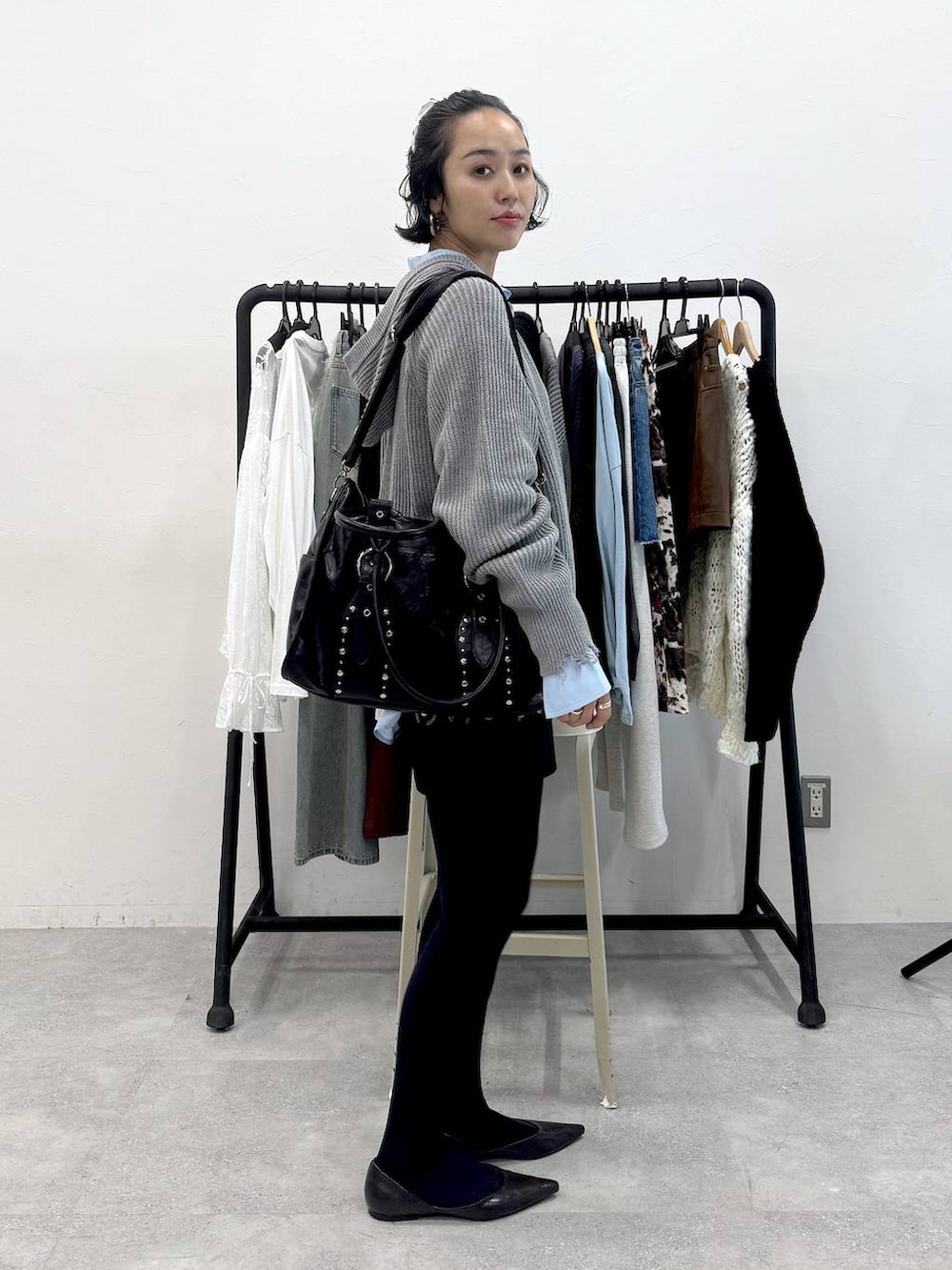 ブラック系のトートバッグ、ブルー系のシャツ/ブラウス、ブラック系のスカートを着用したレディースの秋コーディネートの2枚目の写真