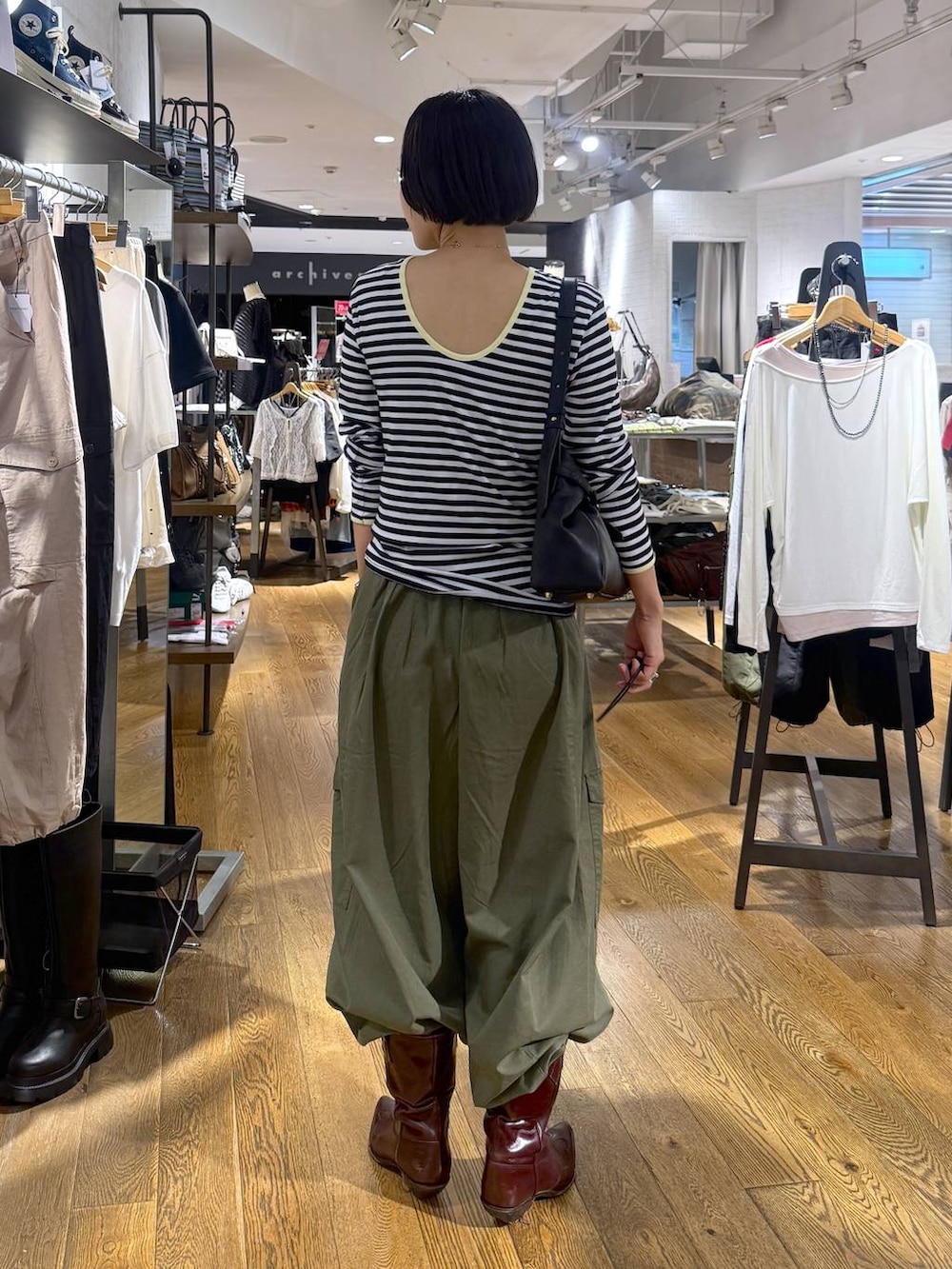 グリーン系のカーゴパンツ、ブラック系のショルダーバッグを着用したレディースの夏コーディネートの3枚目の写真
