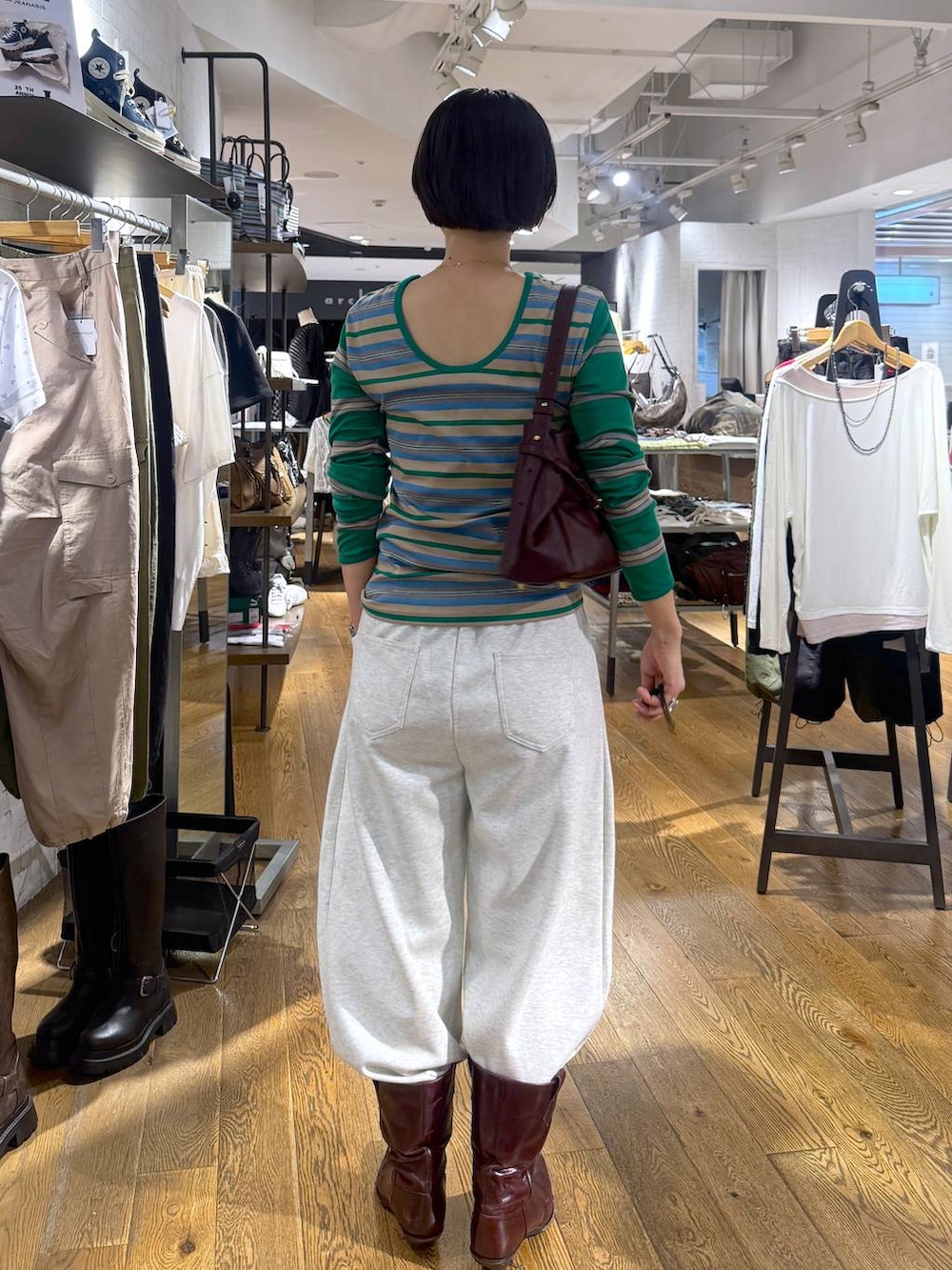 レッド系のショルダーバッグ、ベージュ系のスウェットパンツを着用したレディースの夏コーディネートの3枚目の写真