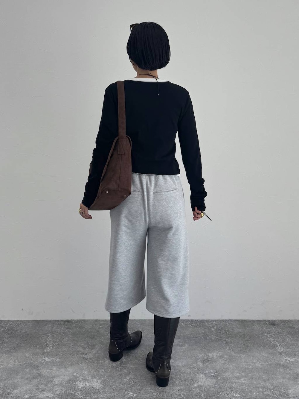 ブラック系のブーツ、ブラウン系のショルダーバッグを着用したレディースの冬コーディネートの3枚目の写真