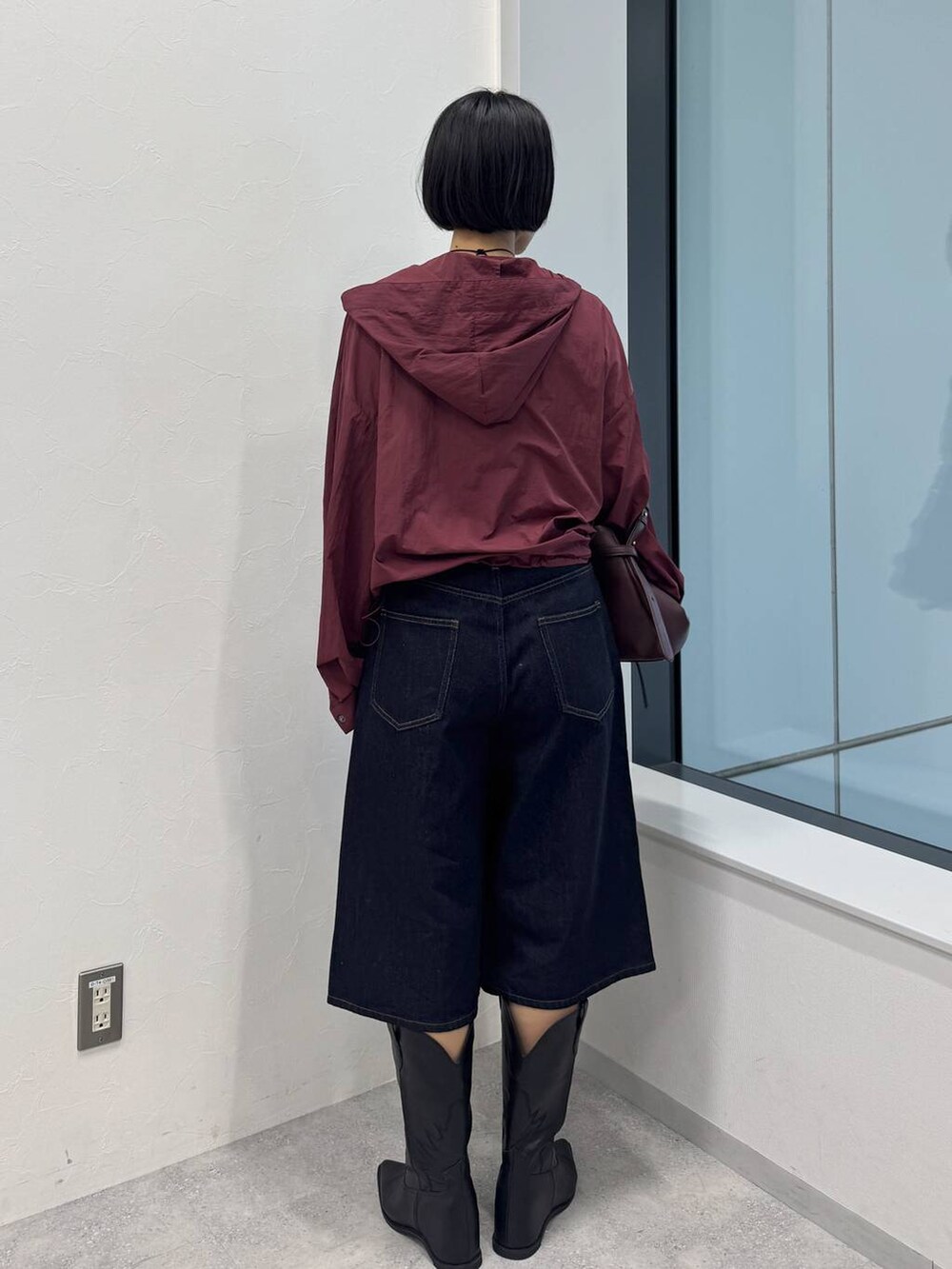 レッド系のショルダーバッグ、ブラック系のブーツを着用したレディースの夏コーディネートの4枚目の写真