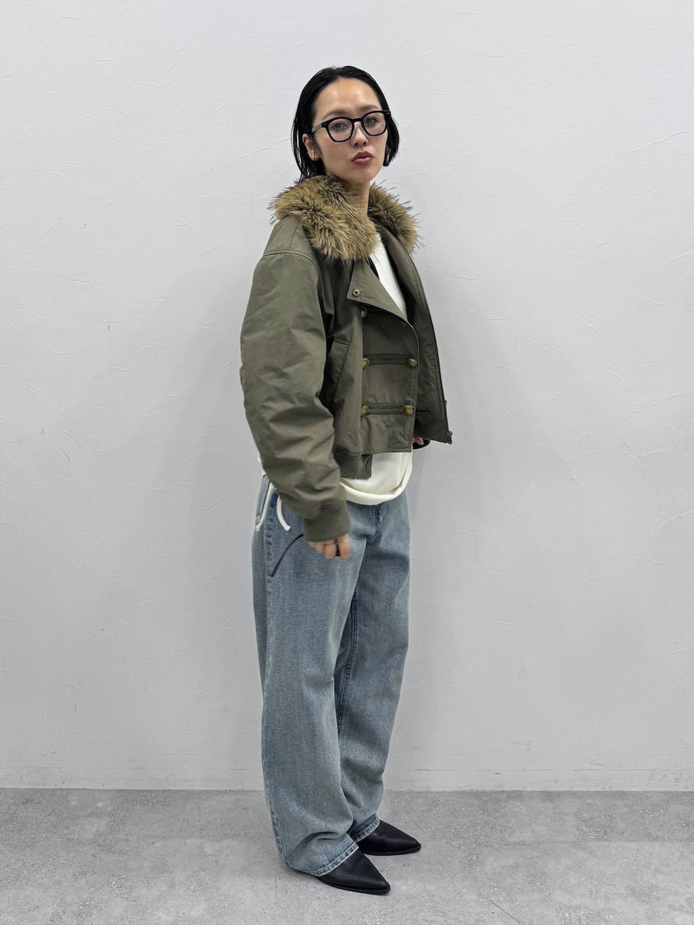 ブルー系のデニムパンツ、ブラック系のブーツ、ホワイト系のTシャツ/カットソーを着用したレディースの秋コーディネートの2枚目の写真
