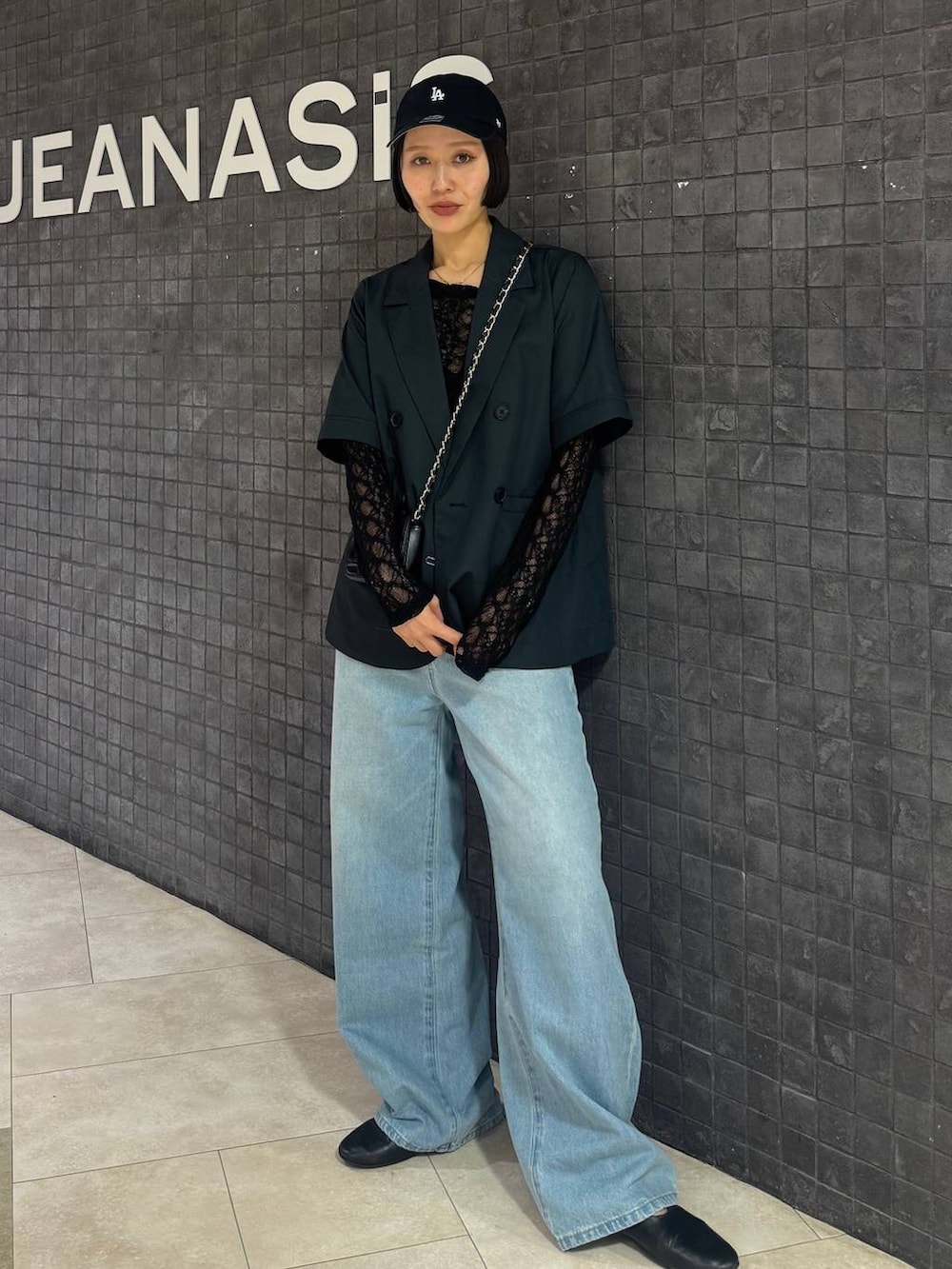 ブラック系のTシャツ/カットソー、ブルー系のデニムパンツ、グレー系のテーラードジャケットを着用したレディースの春コーディネートの2枚目の写真