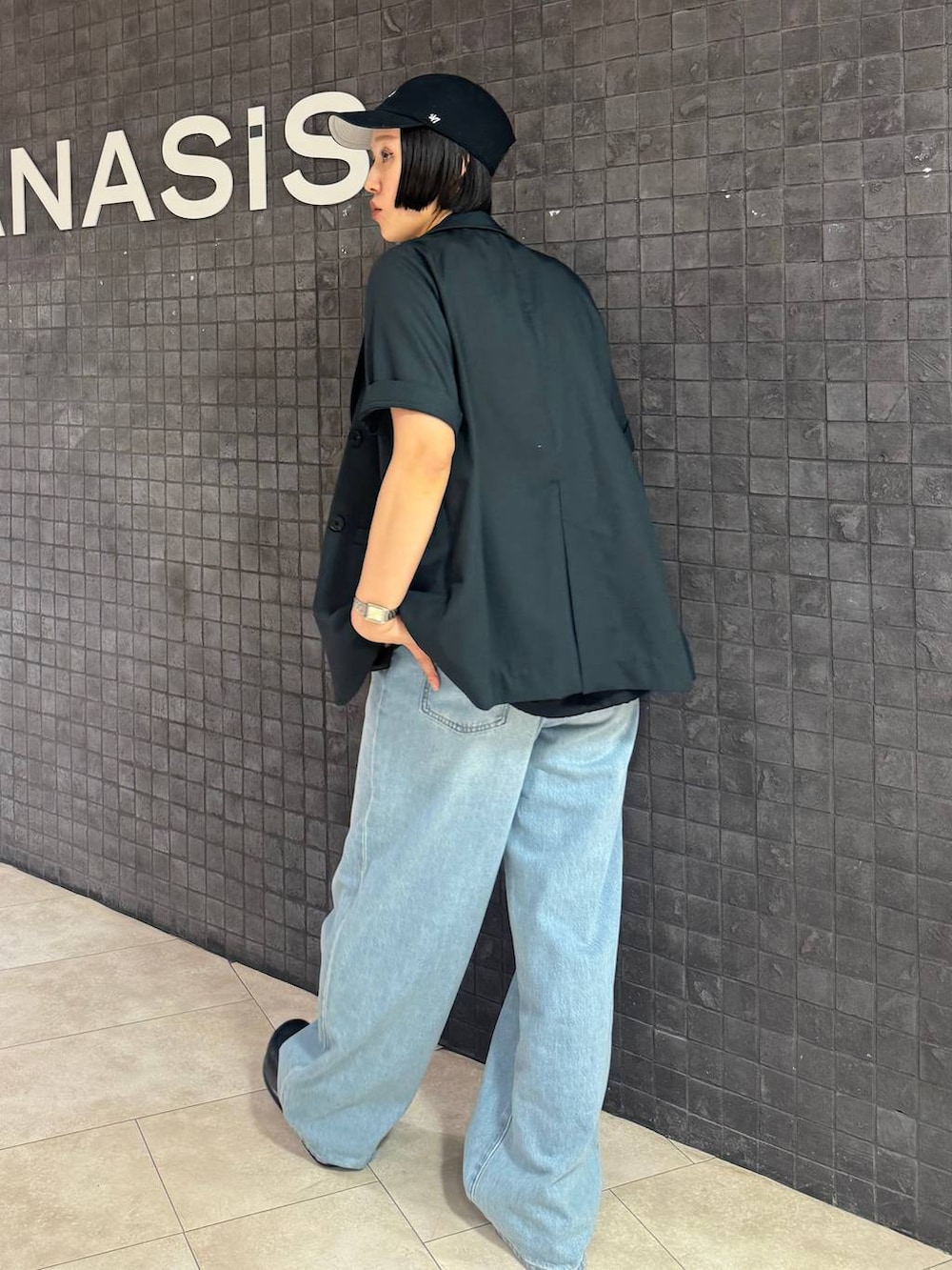 ブラック系のローファー、ブルー系のデニムパンツ、レッド系のタンクトップを着用したレディースの春コーディネートの3枚目の写真