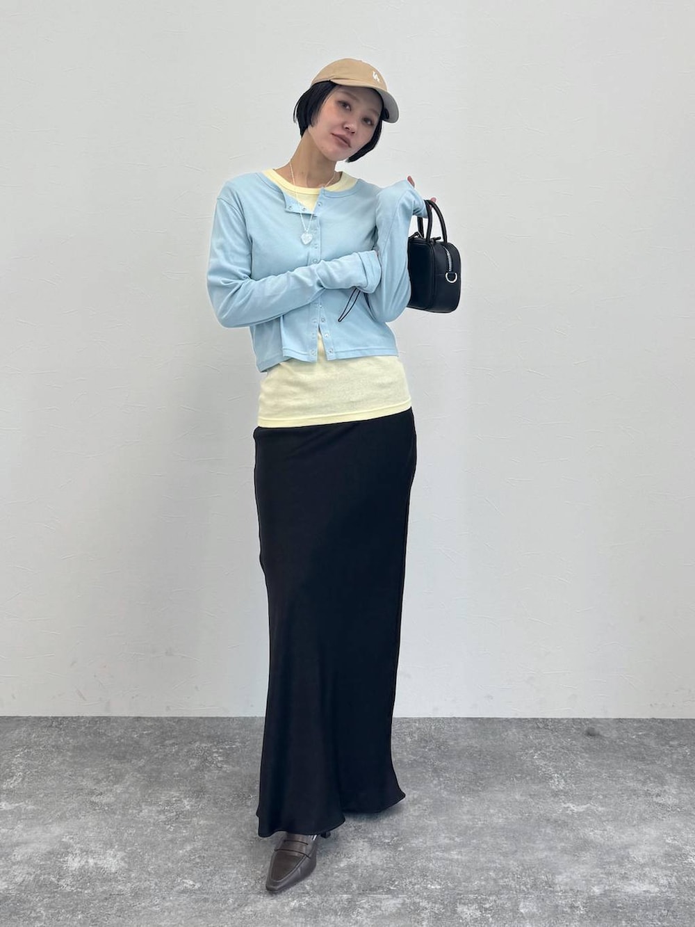 ブラウン系のローファー、ブラック系のショルダーバッグ、ブラック系のスカートを着用したレディースの冬コーディネートの2枚目の写真