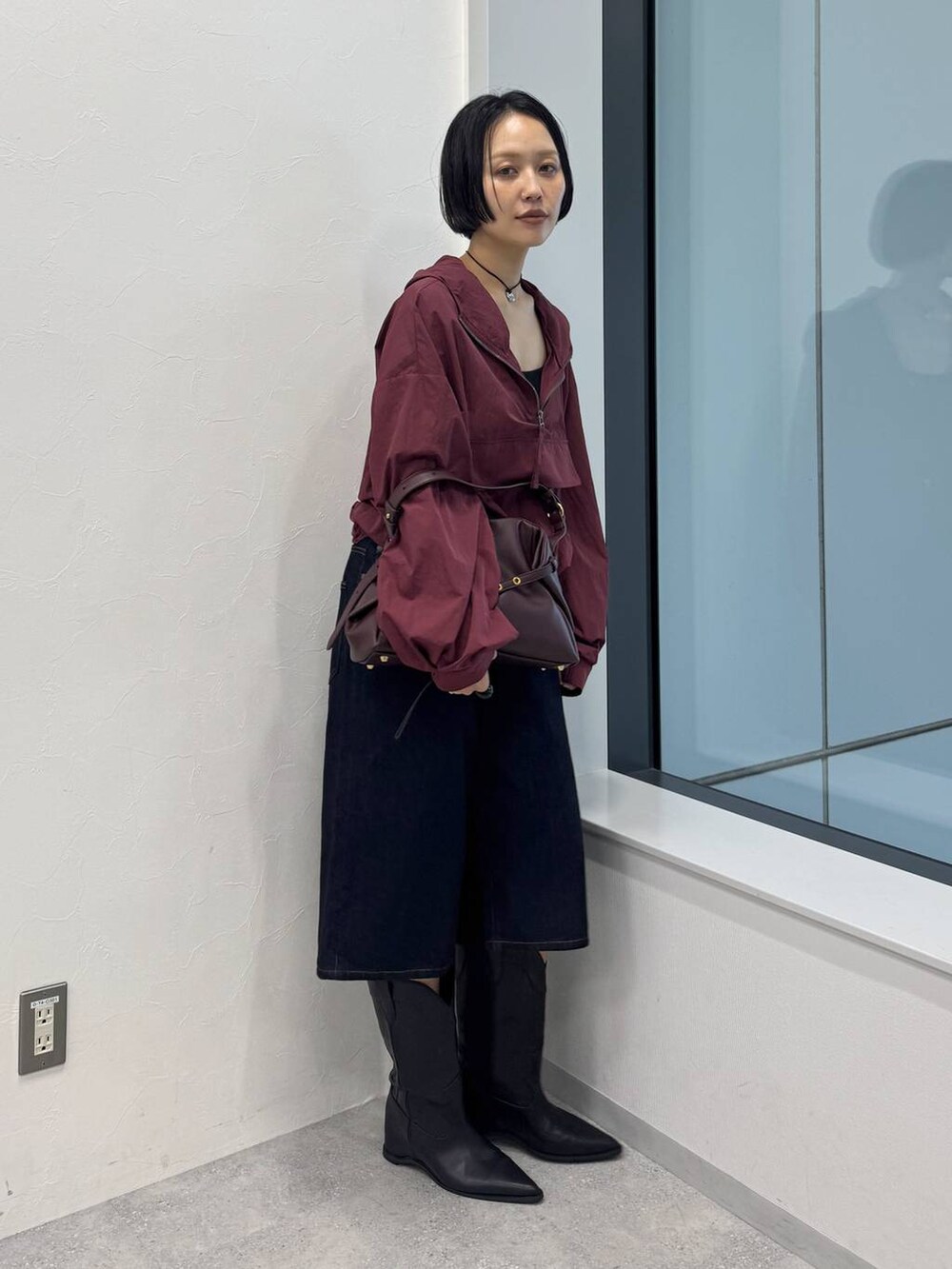 レッド系のショルダーバッグ、ブラック系のブーツを着用したレディースの夏コーディネートの3枚目の写真