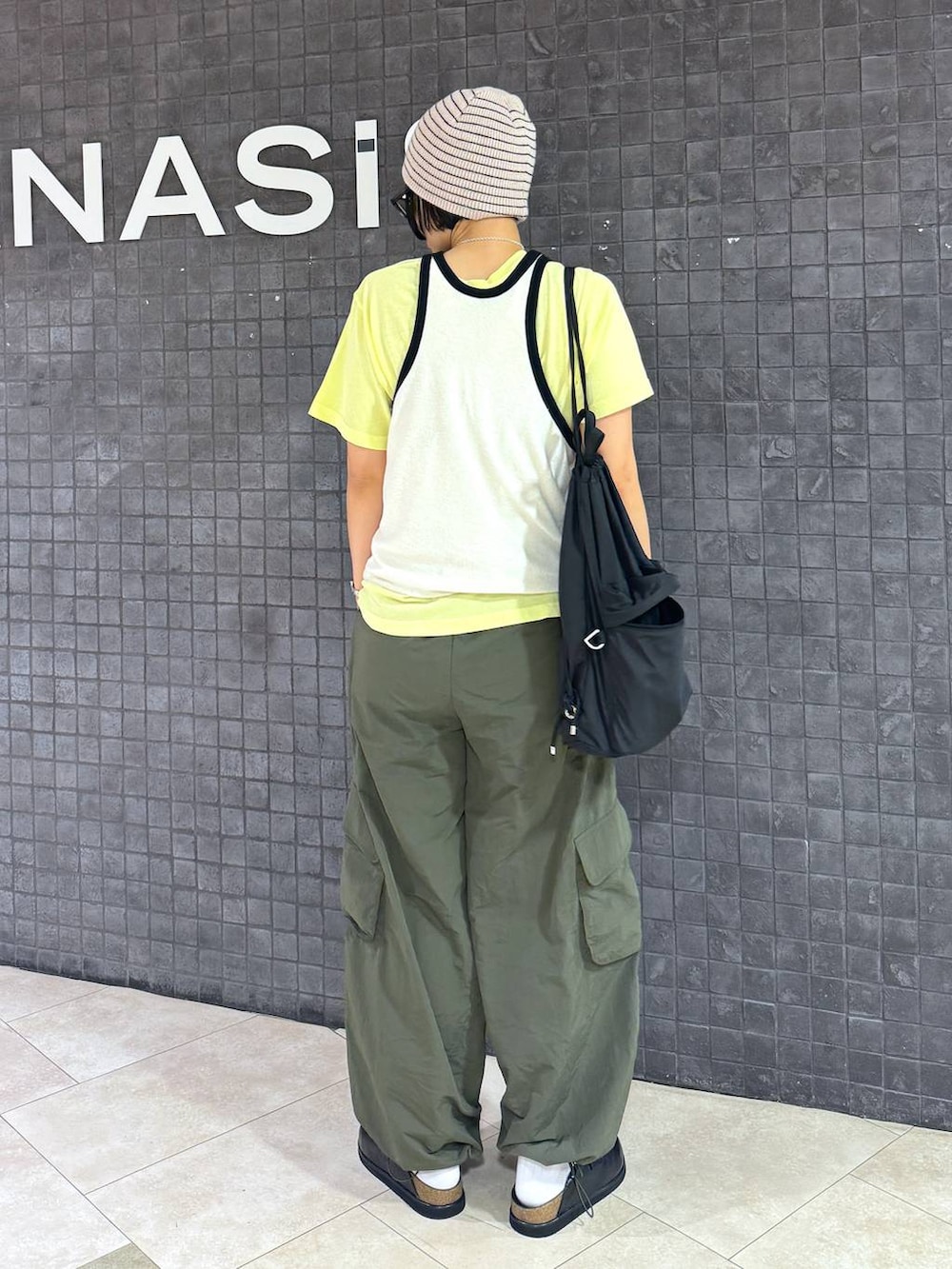 イエロー系のTシャツ/カットソー、ホワイト系のニットキャップ/ビーニーを着用したレディースの夏コーディネートの3枚目の写真