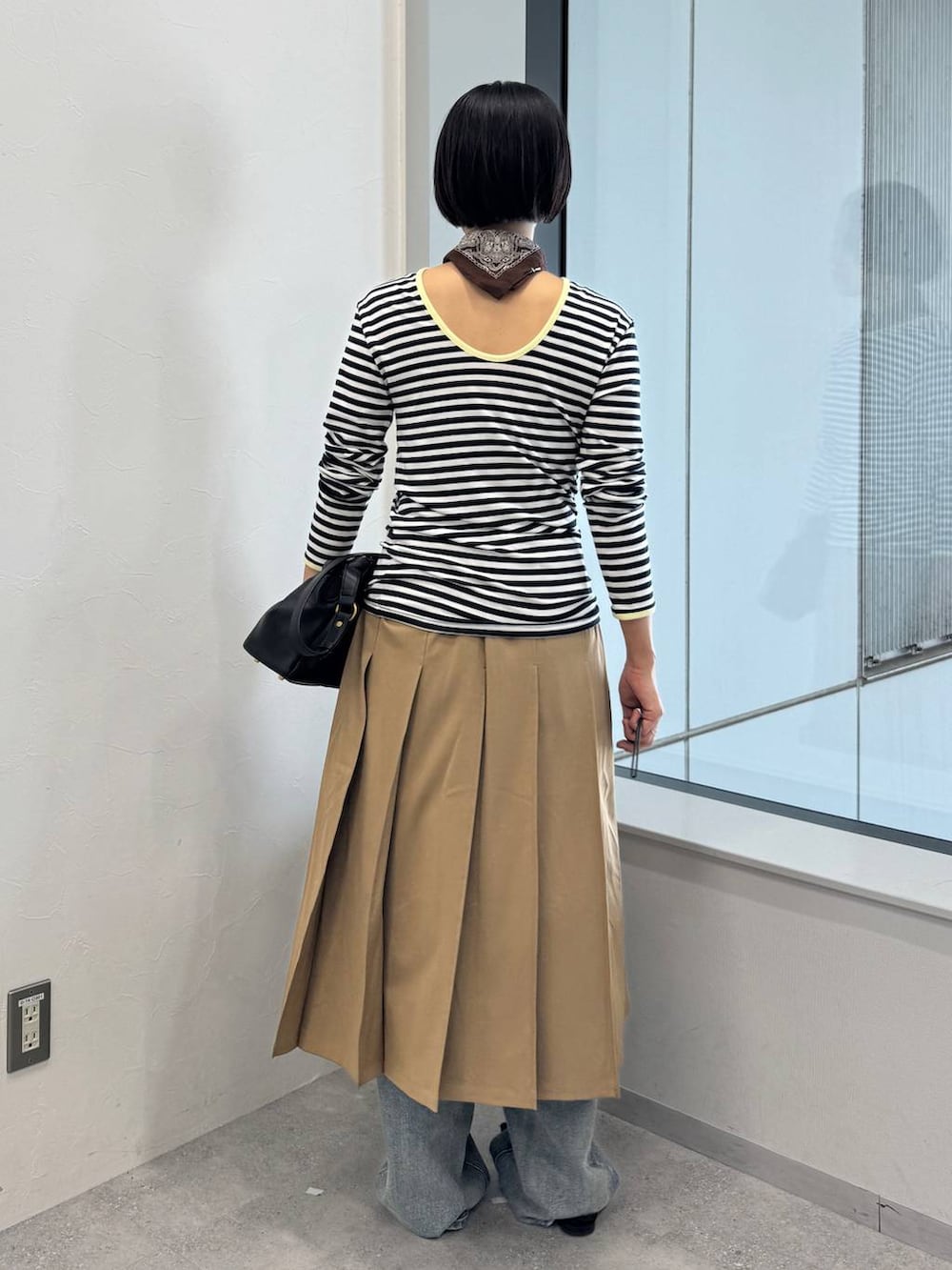 ブルー系のデニムパンツ、ブラック系のショルダーバッグ、ブラック系のサンダルを着用したレディースの夏コーディネートの3枚目の写真
