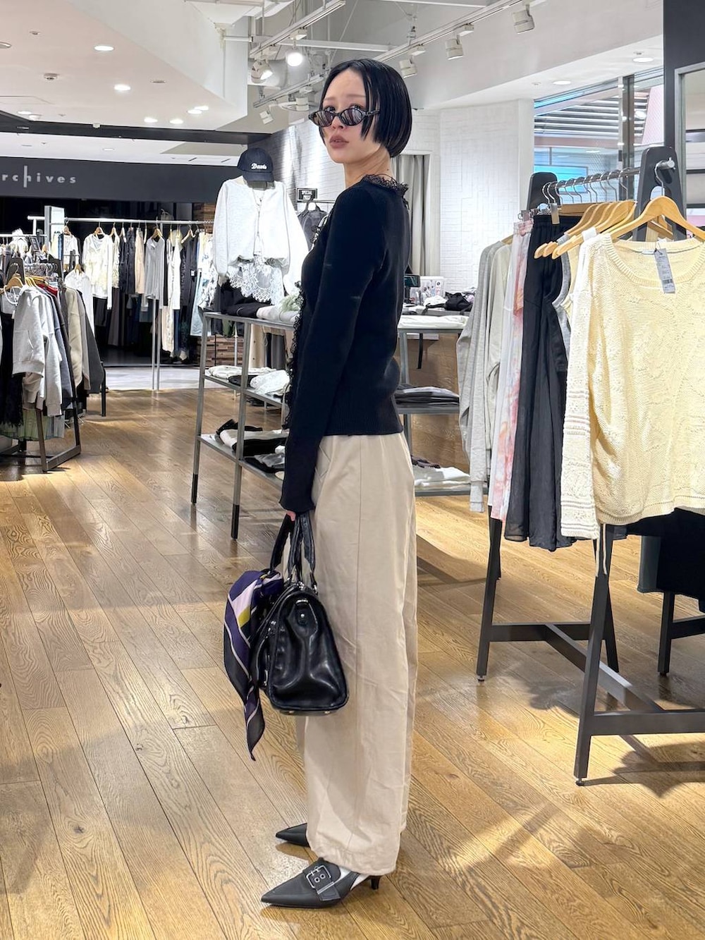 ブラック系のパンプス、ブラック系のボストンバッグ、ベージュ系のその他パンツを着用したレディースの春コーディネートの2枚目の写真