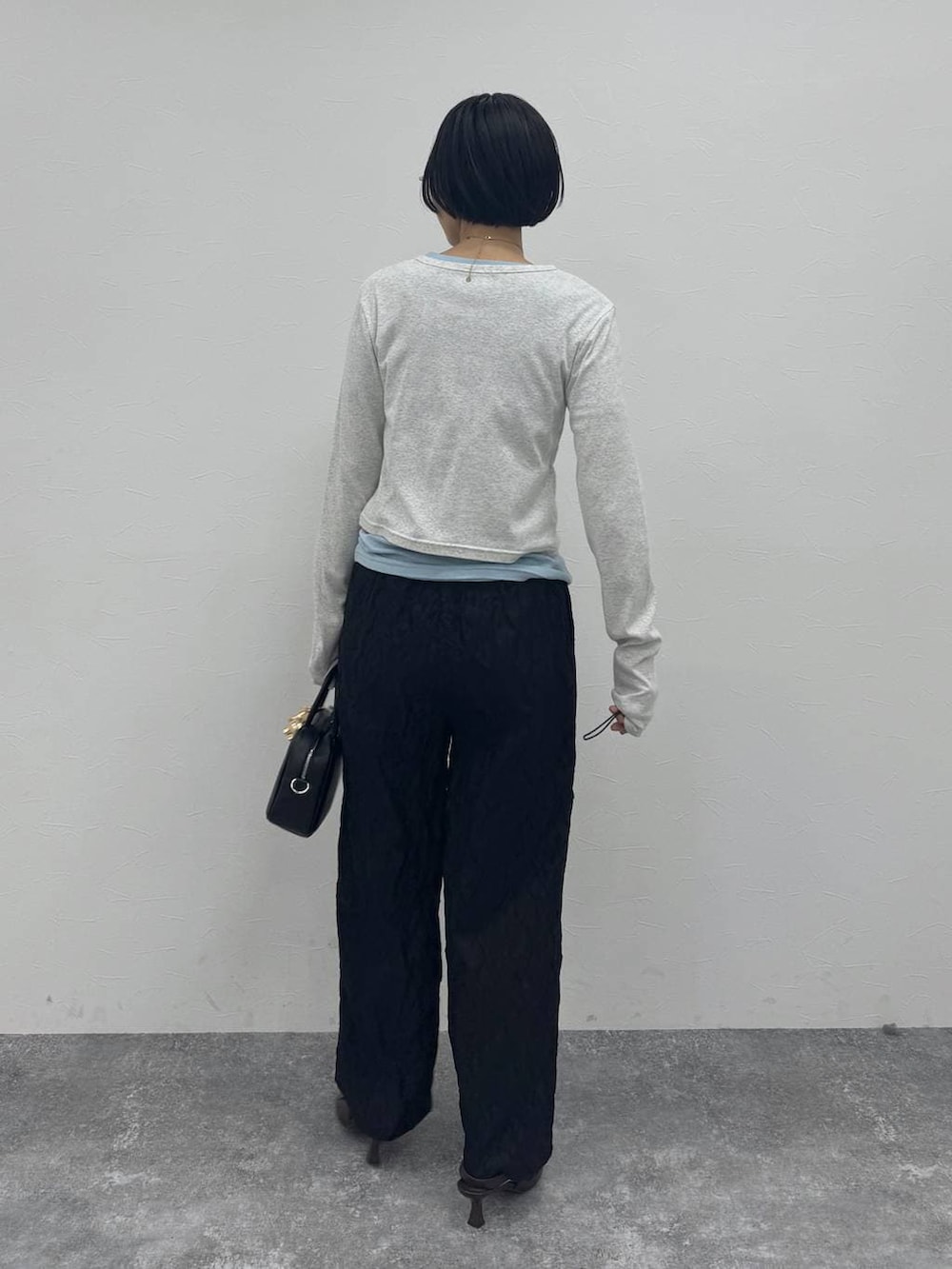 ブラウン系のローファー、ブラック系のショルダーバッグを着用したレディースの冬コーディネートの3枚目の写真