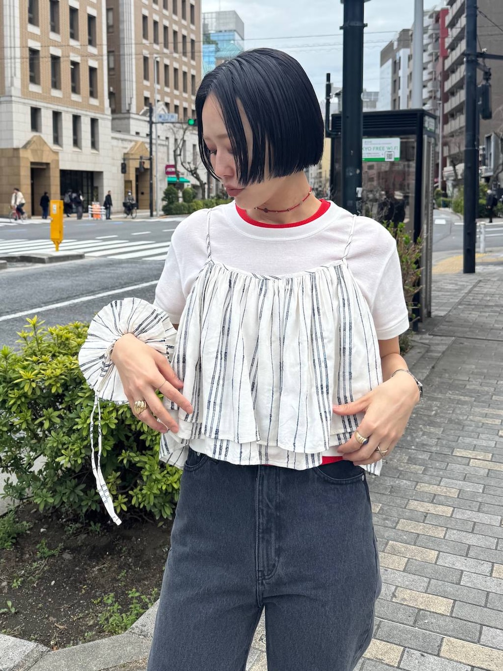 ブラック系のサンダル、ブラック系のデニムパンツを着用したレディースの春コーディネートの9枚目の写真