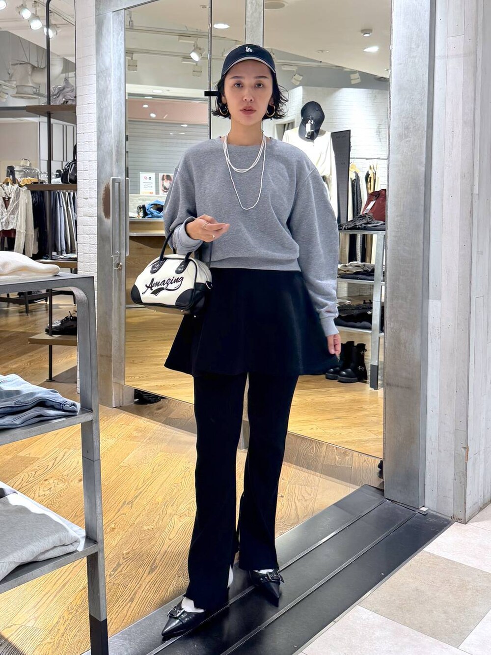 ブラック系のパンプス、ホワイト系のショルダーバッグ、ブラック系のその他パンツを着用したレディースの秋コーディネートの4枚目の写真