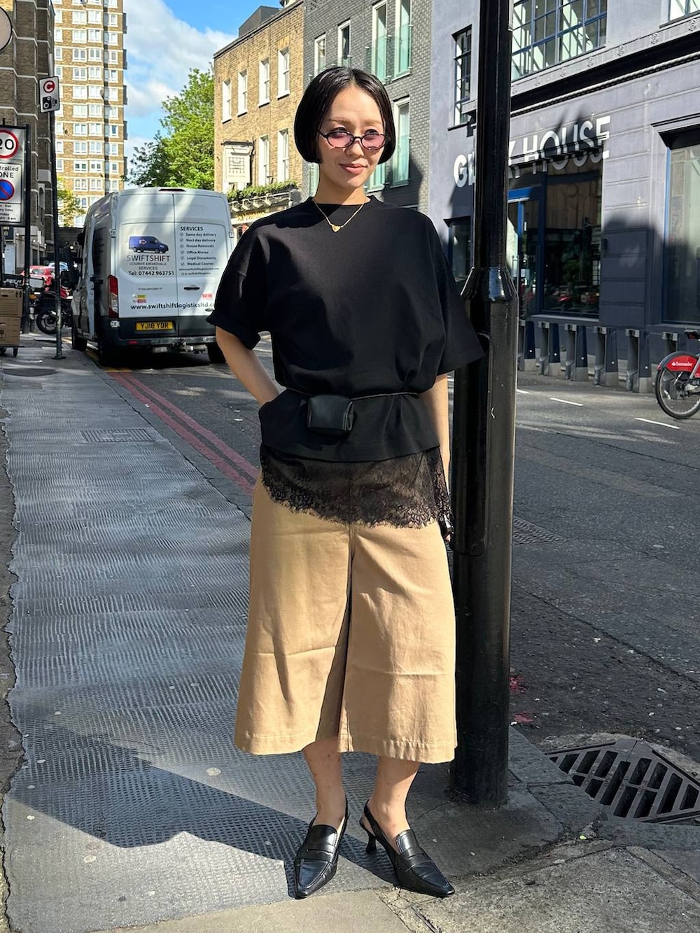 ブラック系のTシャツ/カットソー、ブラック系のベルト、ブラック系のサングラスを着用したレディースの夏コーディネートの5枚目の写真