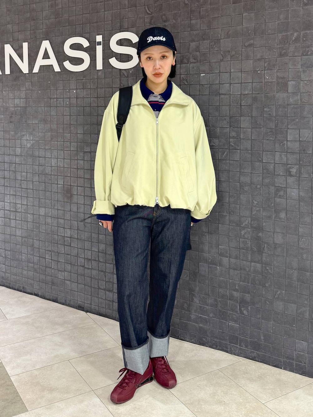 ブラック系のバックパック/リュック、ブルー系のデニムパンツ、ブルー系のポロシャツを着用したレディースの春コーディネートの4枚目の写真