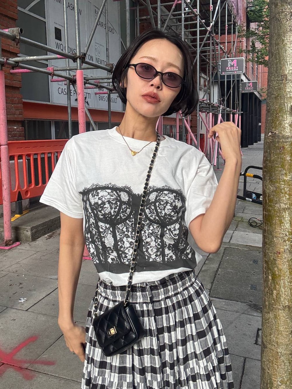 ブラック系のスカート、ホワイト系のTシャツ/カットソー、ブラック系のサングラスを着用したレディースの夏コーディネートの7枚目の写真