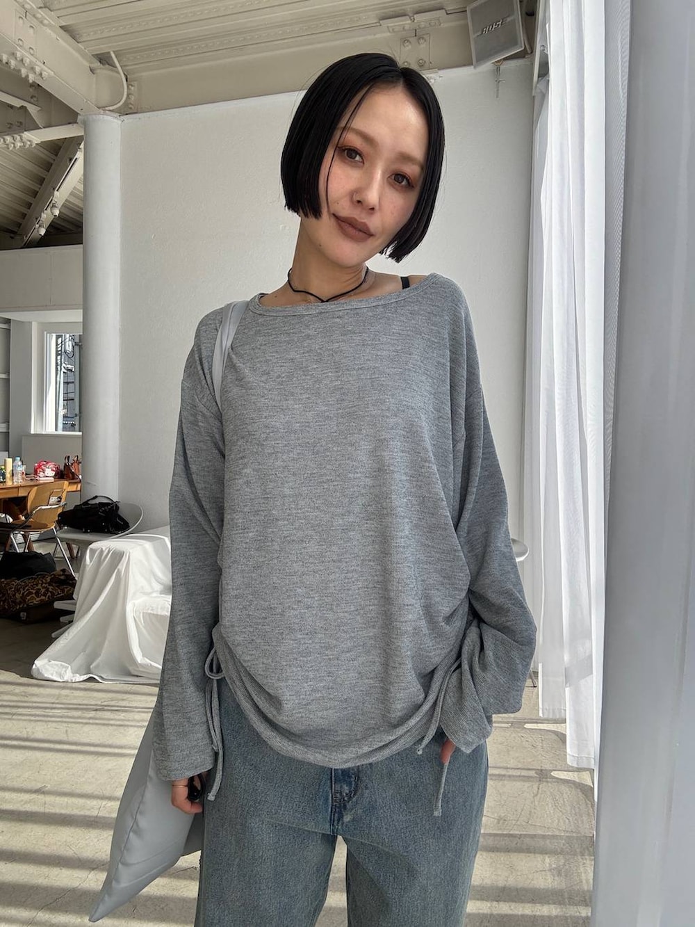 ブルー系のデニムパンツ、ブラック系のブーツ、グレー系のTシャツ/カットソーを着用したレディースの秋コーディネートの4枚目の写真