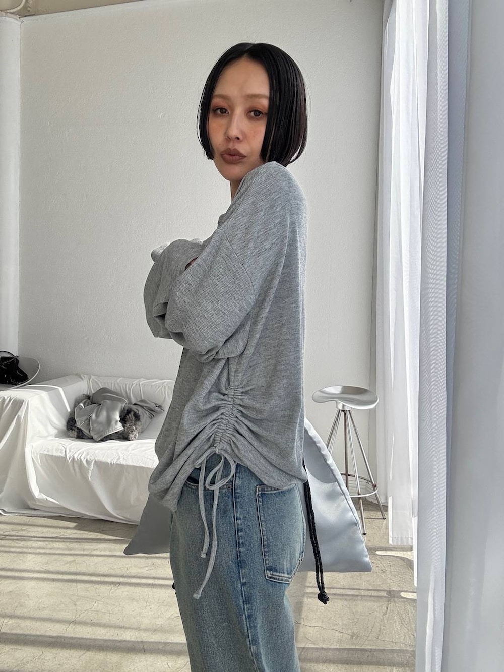 ブルー系のデニムパンツ、ブラック系のブーツ、グレー系のTシャツ/カットソーを着用したレディースの秋コーディネートの5枚目の写真